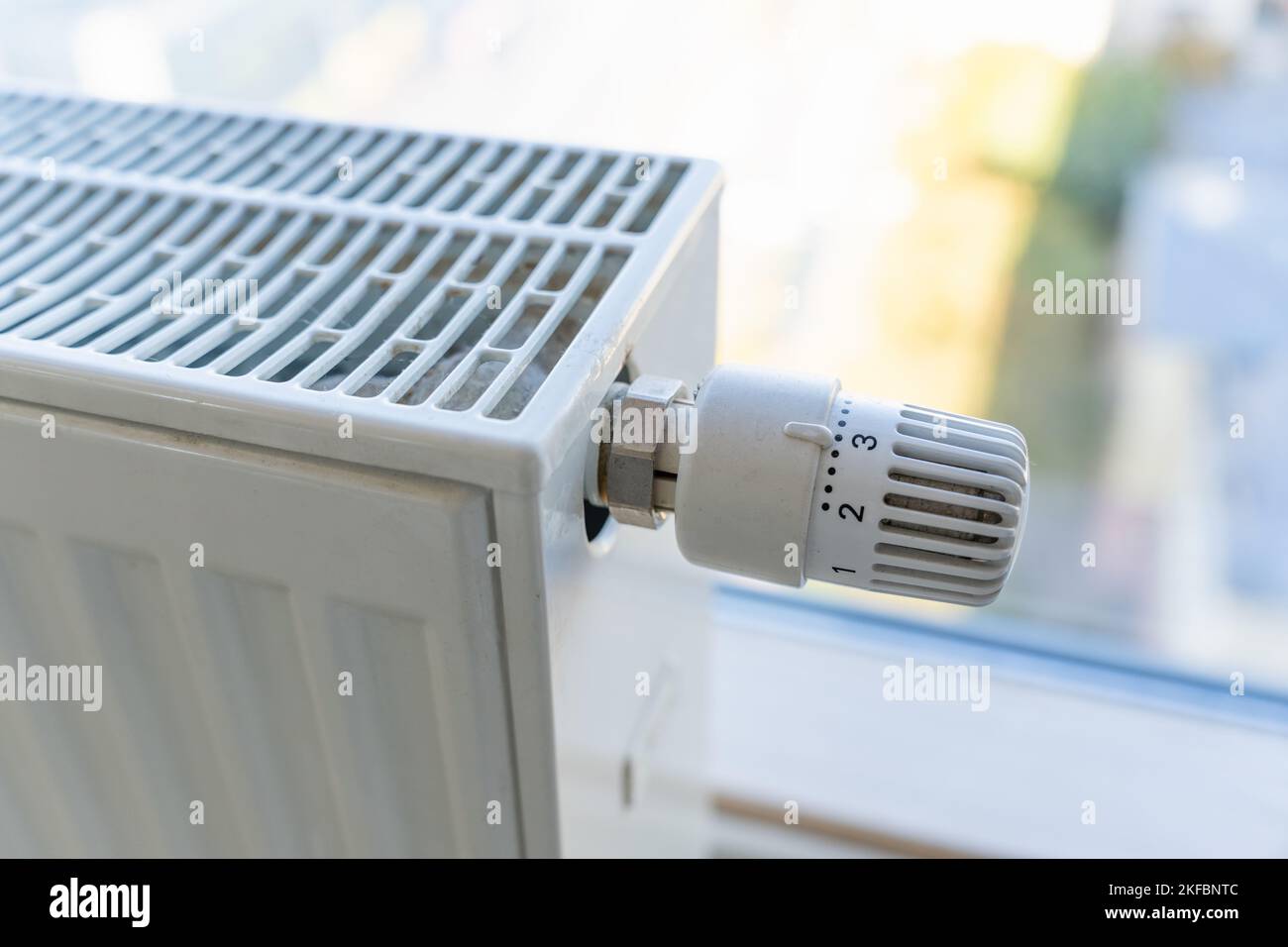 Heating radiator with adjustment knob installed on the middle position in a residential apartment Stock Photo
