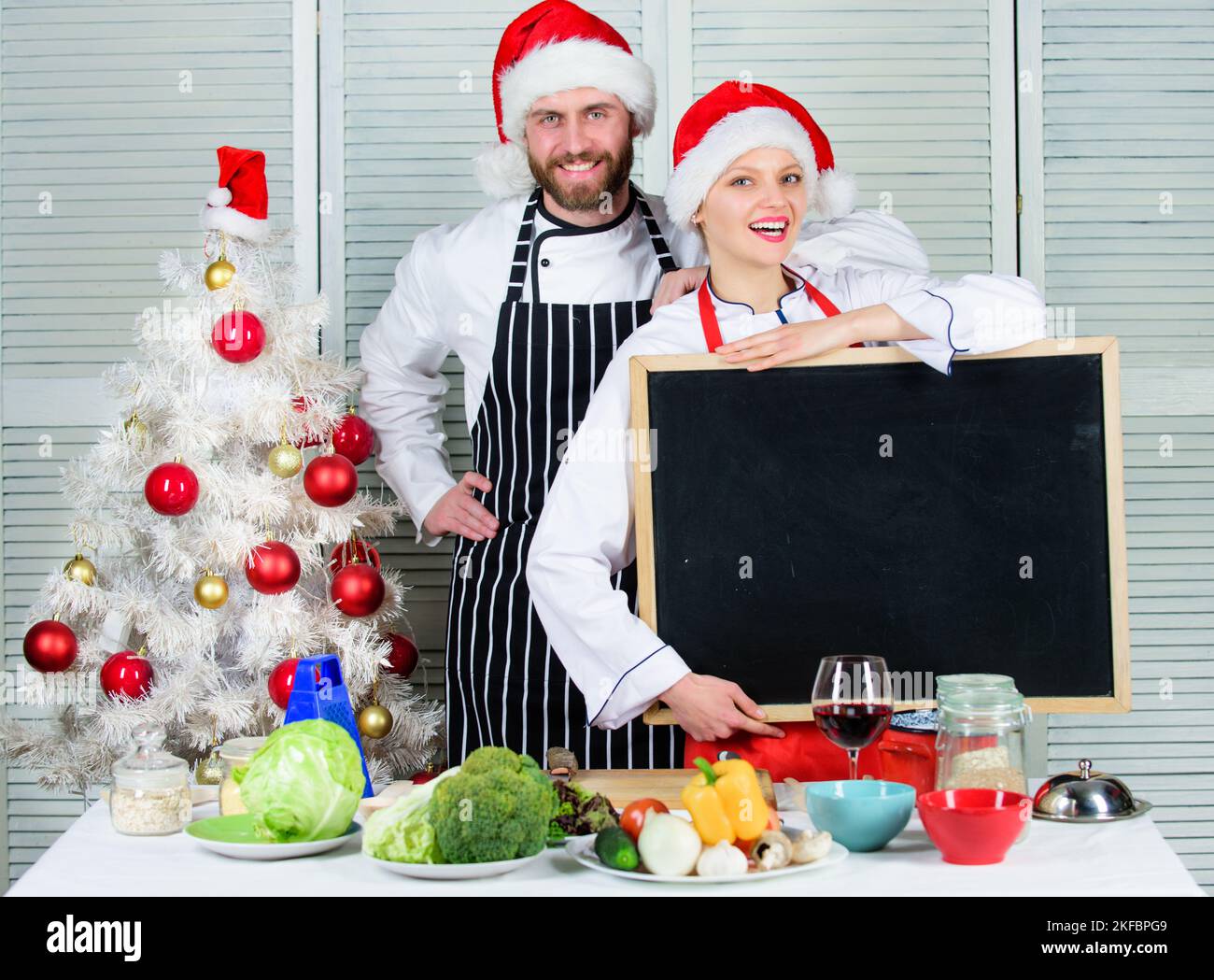 Man and woman chef santa hat near christmas tree hold blackboard copy ...