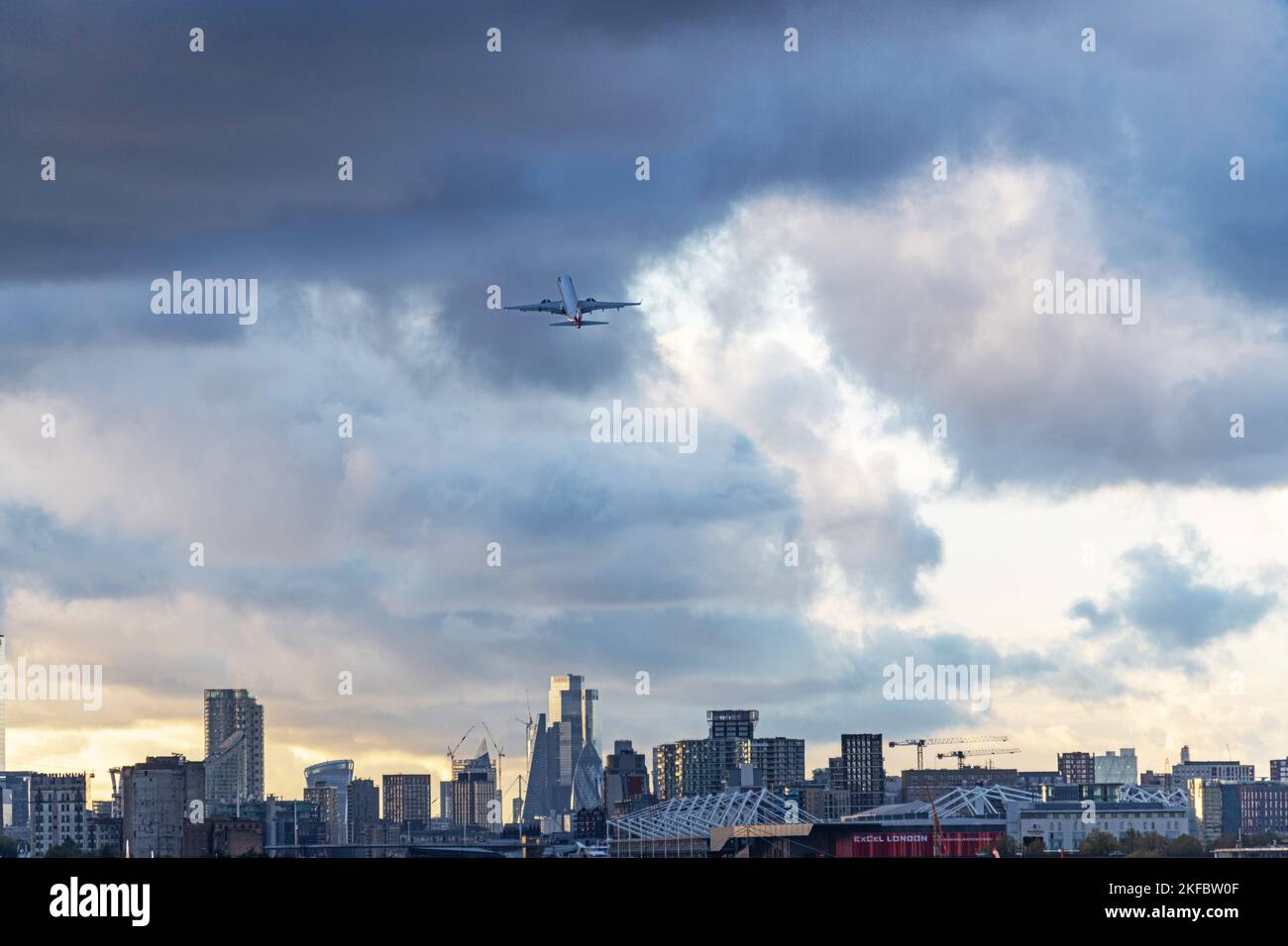 A British Airways Embraer ERJ-190 takes Off into dark clouds at London City Airport. Stock Photo