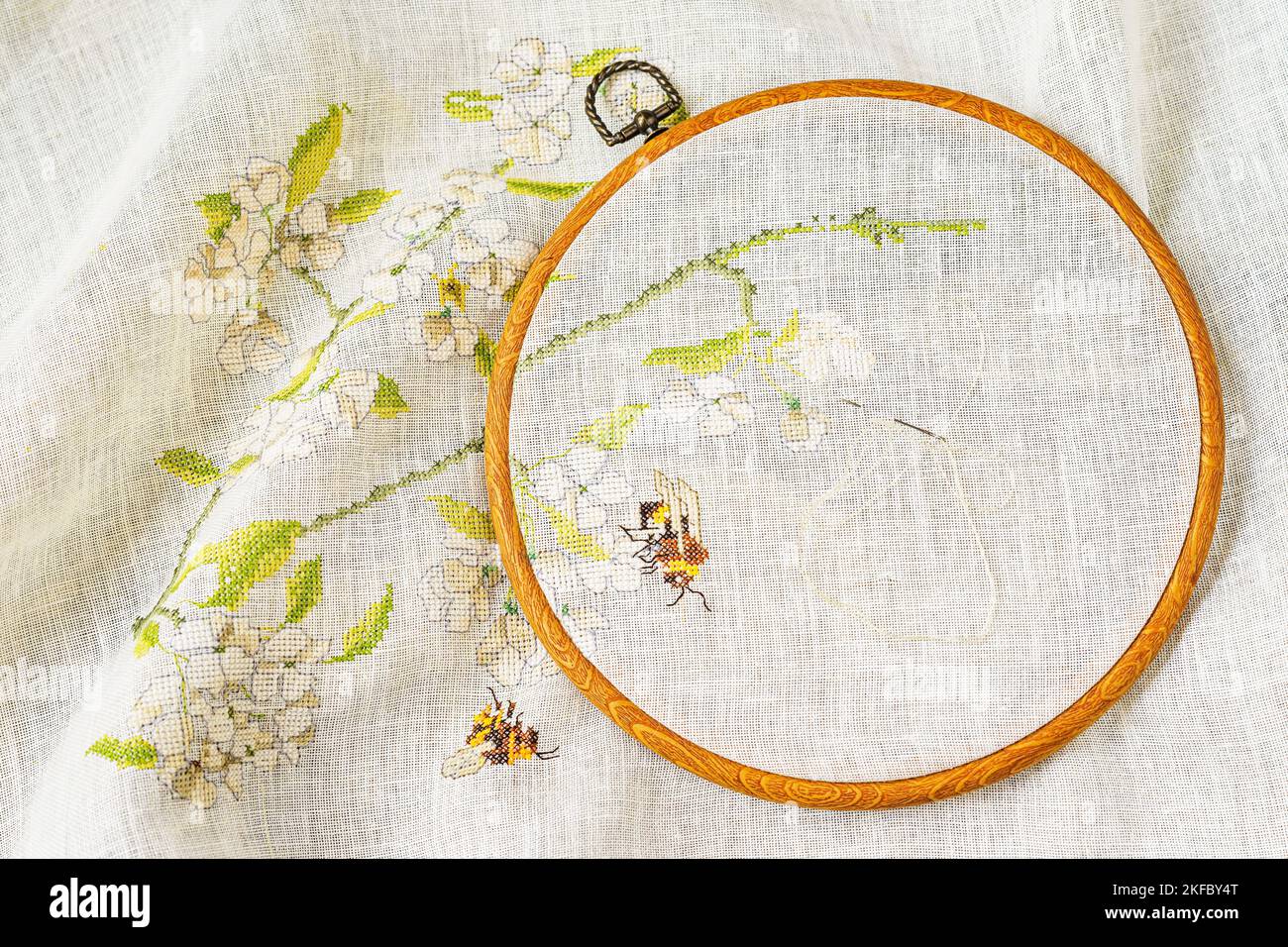 Embroidery hoop with fabric, with floral summer pattern on canvas closeup. Concept handmade hobby Stock Photo