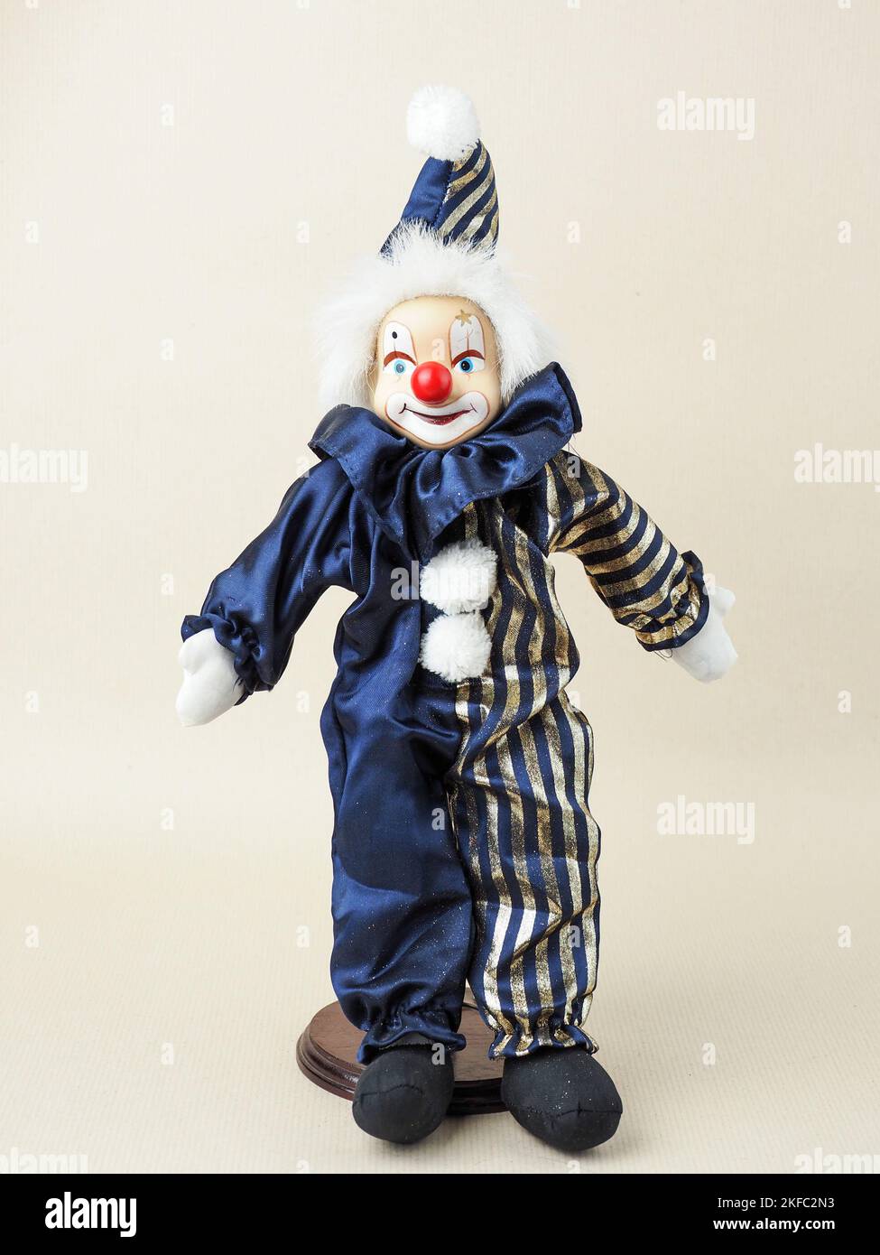 Vintage white clown with red nose doll in a blue suit with cap