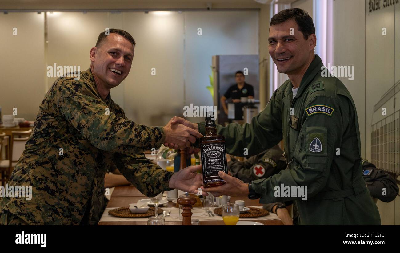 U.S. Marine Corps Lt. Col. William C. Woodward, left, commander of Marine Light Attack Helicopter Squadron (HMLA) 773, Marine Forces Reserve, presents a gift to Capitao de mar e guerra Marcos de Oliveria Macedo (Colonel Brazilian Marine Corps), operations group commander at Santa Cruz Air Force Base, during exercise UNITAS LXIII in Rio de Janeiro, Sept. 5, 2022. The gift was given as a symbol of gratitude. UNITAS is the world’s longest-running annual multinational maritime exercise that focuses on enhancing interoperability among multiple nations and joint forces during littoral and amphibious Stock Photo