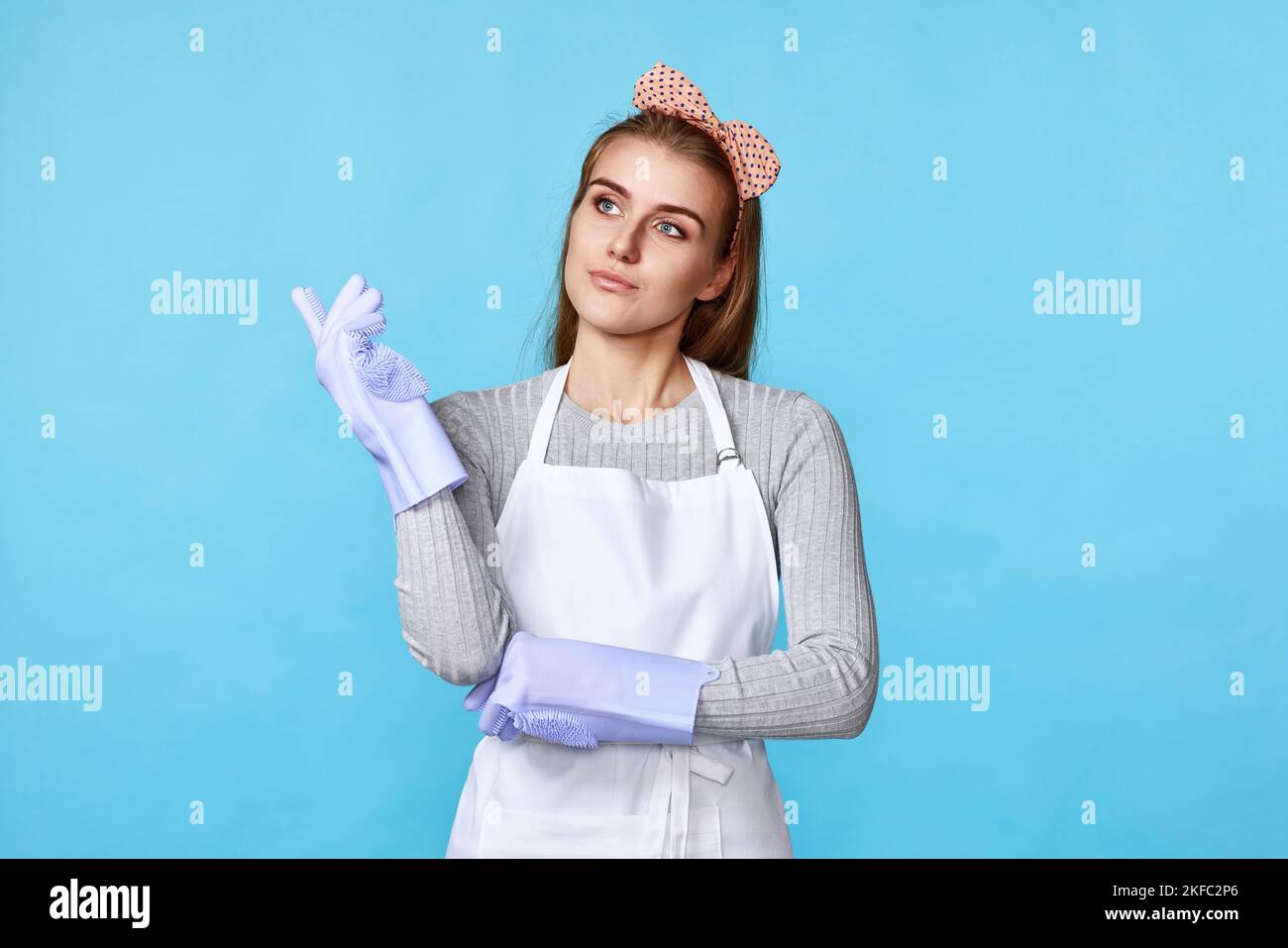 woman in rubber gloves and apron holding index finger up Stock Photo ...