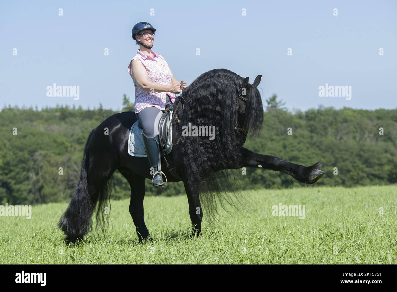 woman rides Friesian horse Stock Photo - Alamy