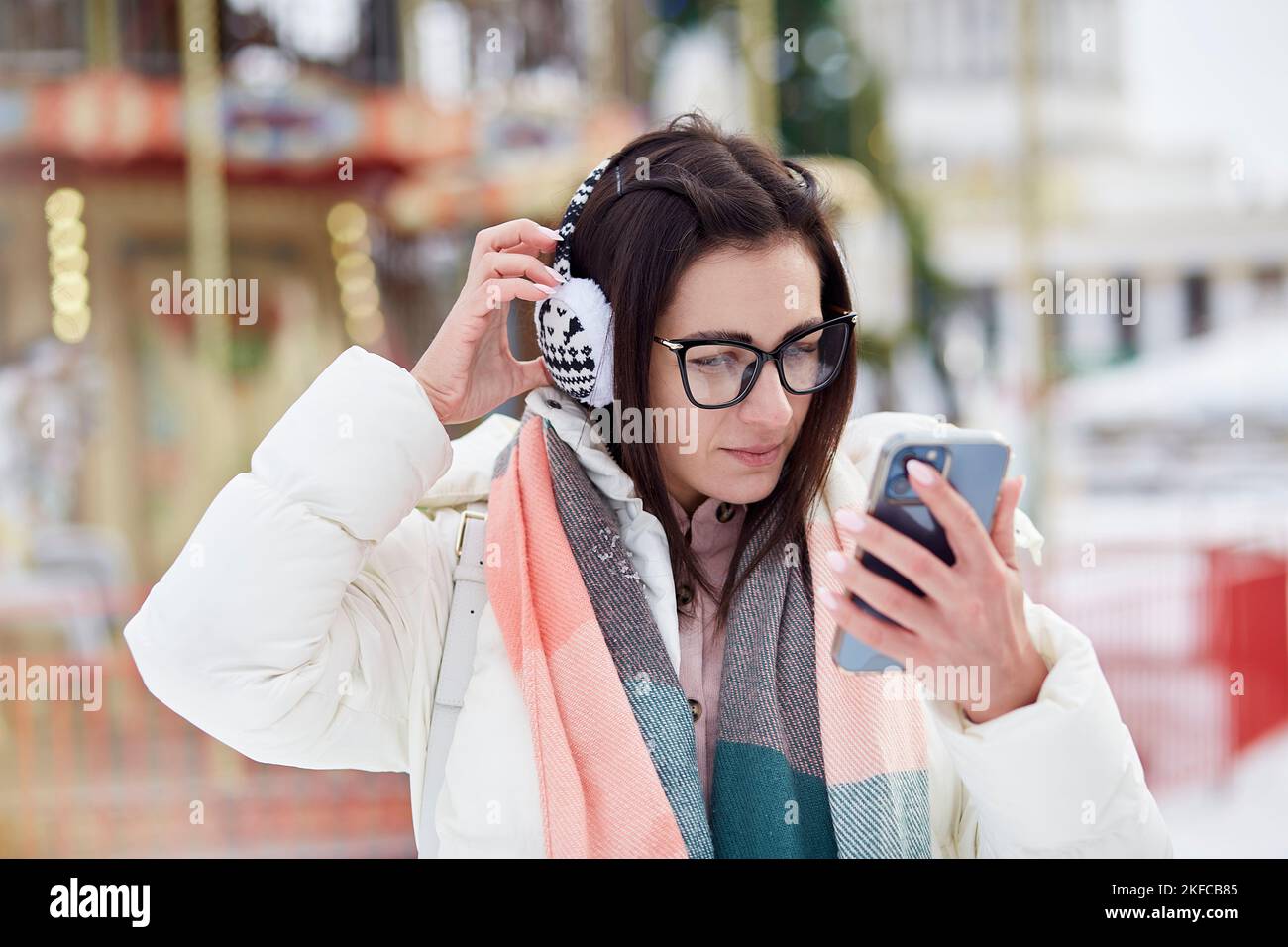 Portrait of young stylish woman making selfie outdoor at the New Year's fair. Winter fun. Good mood. Authentic lifestyle. Stock Photo