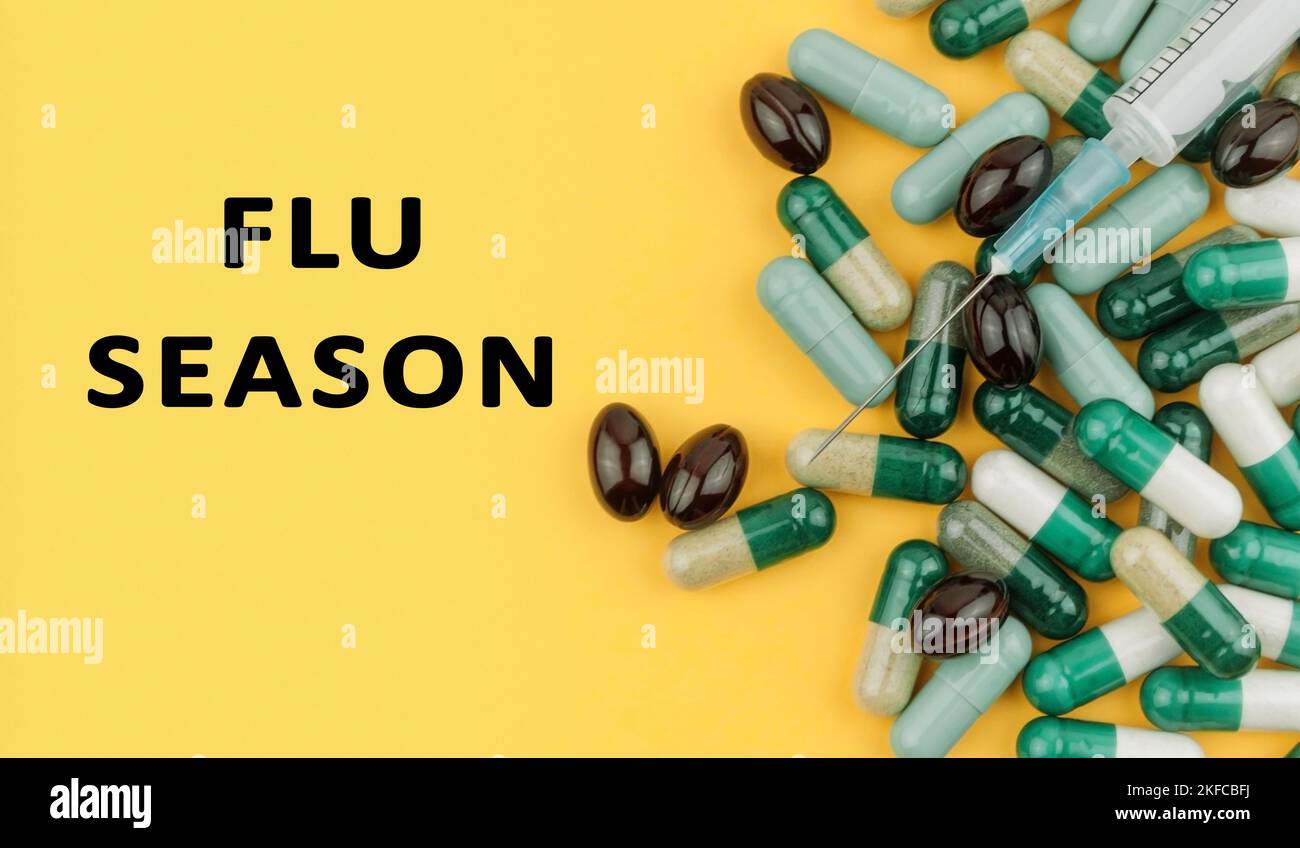 message on yellow background with pills and vitamins Flu season. The concept of protection against coronavirus COVID-19. Flat lay Stock Photo