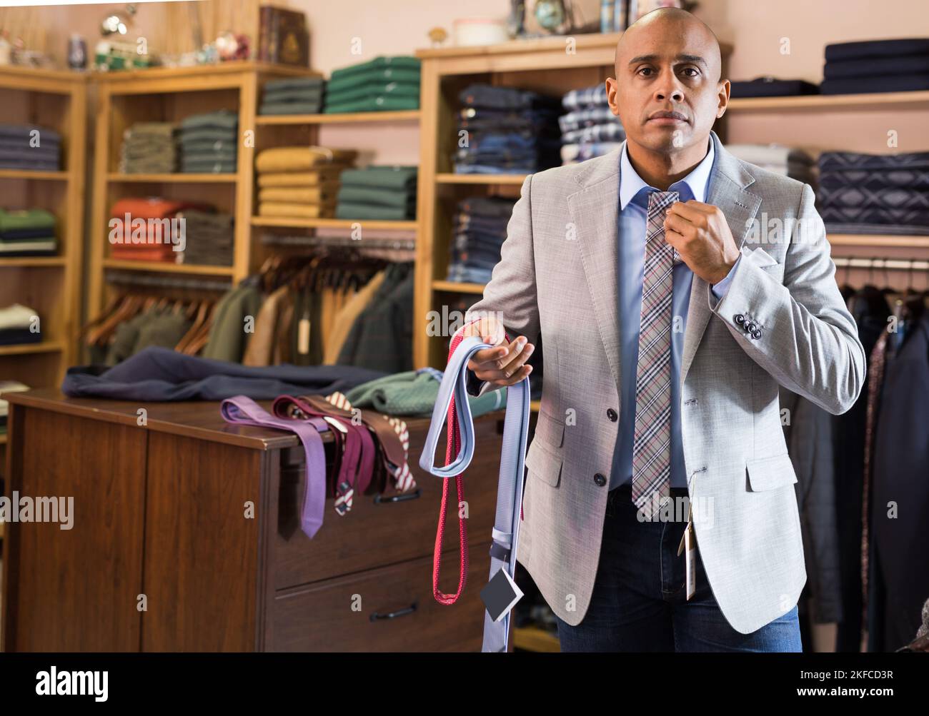 Man choosing new tie in clothing boutique Stock Photo - Alamy