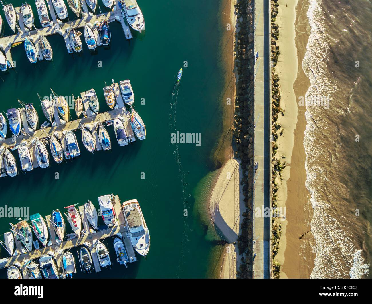 An aerial of many ships and boats anchored at a harbor on a turquoise ...