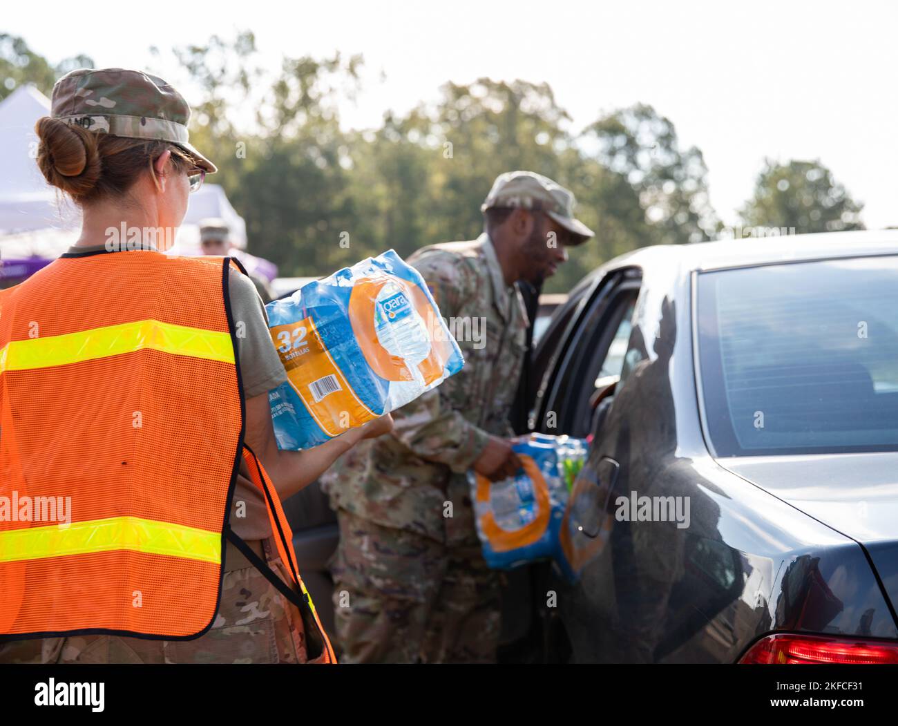 Soldiers with the 298th Support Battalion, 184th Sustainment Command, Mississippi Army National Guard, distribute water at Davis Road Park near Jackson, Mississippi, Sept. 7, 2022. More than 11,000 cars received bottled water, hand sanitizer and non-potable water from water buffalo trucks since the site opened Sept. 1. Stock Photo