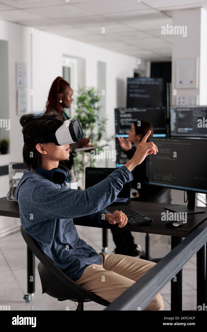 Software developer wearing virtual reality headset working to develop