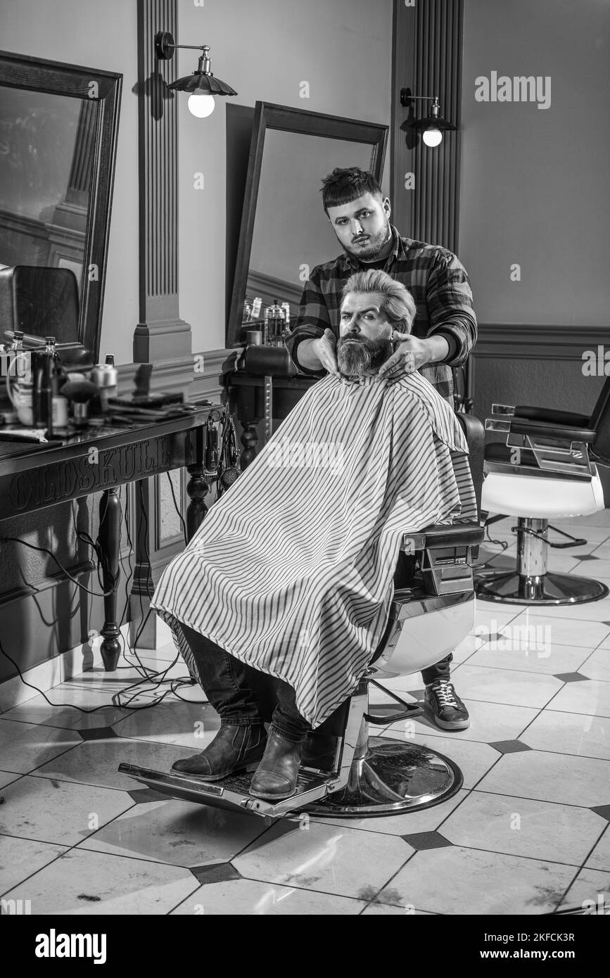 Time for new haircut. hipster man with beard cutting his hair in a