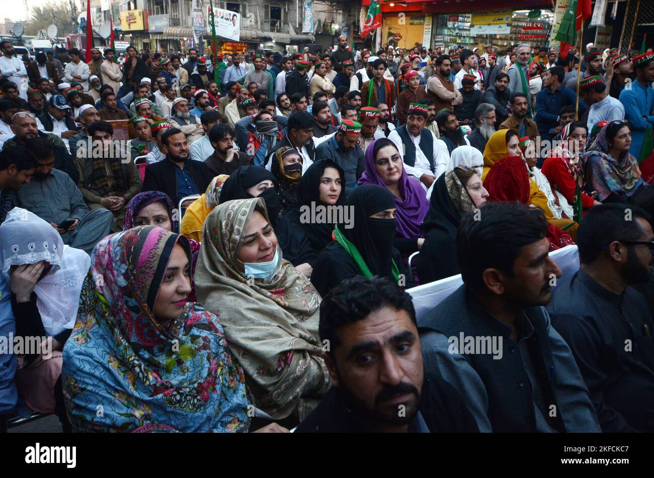 Peshawar, Pakistan, 17/11/2022, Supporters watch a video-linked address of former Prime Minister Imran Khan, head of the Pakistan Tehrik-e-Insaf (PTI) party, as the protest march continues followings its resumption, days after an assassination attempt on the former prime minister halted the rally at G T Road in Peshawar. The march to the capital Islamabad resumed from eastern Punjab Wazirabad city, as Khan keeps pressing for snap elections, a demand rejected by the government of Prime Minister Sharif. The Tehreek-e-Insaf party began its march from Lahore in late October, but it was stopped due Stock Photo