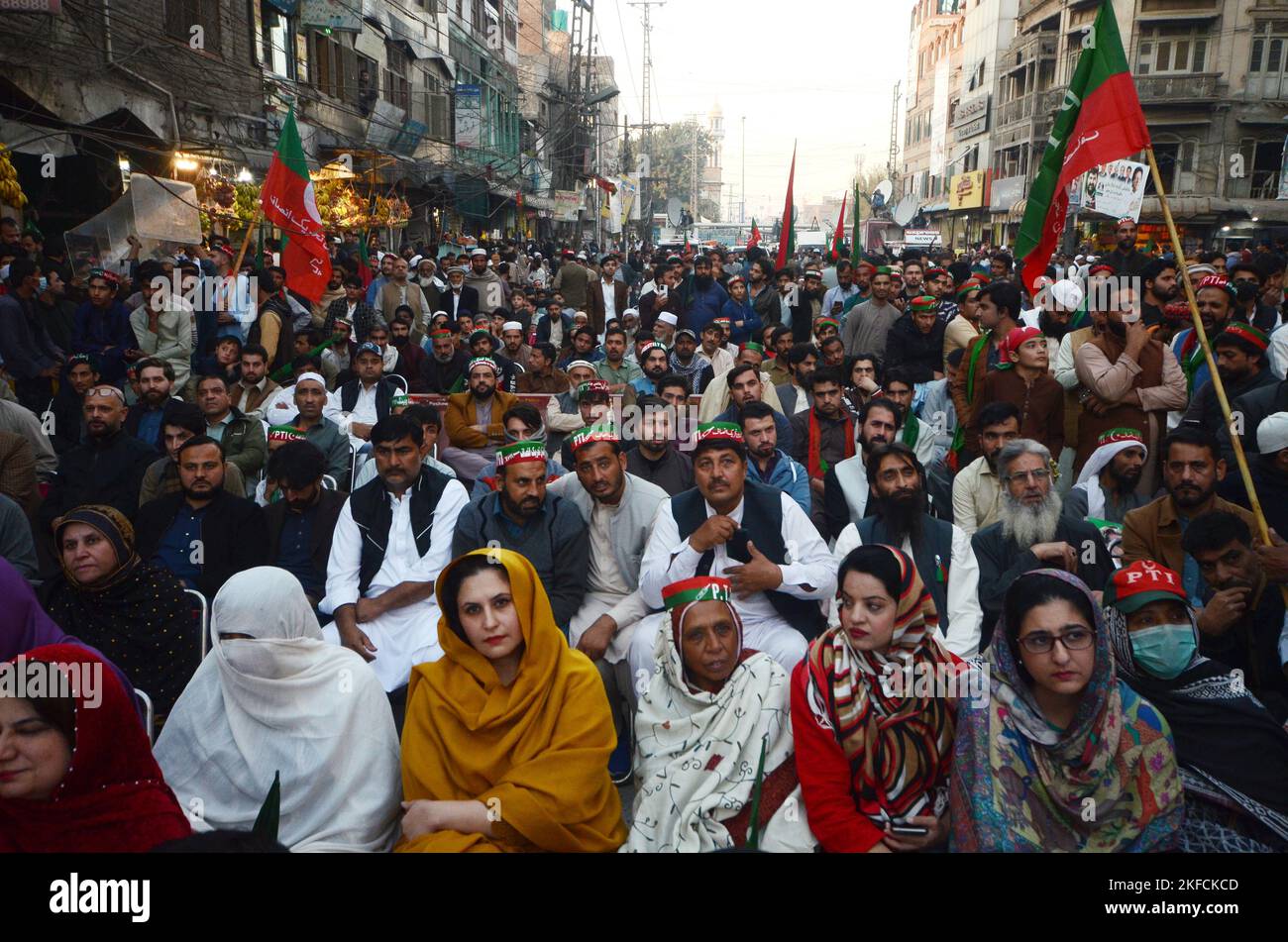 Peshawar, Pakistan, 17/11/2022, Supporters watch a video-linked address of former Prime Minister Imran Khan, head of the Pakistan Tehrik-e-Insaf (PTI) party, as the protest march continues followings its resumption, days after an assassination attempt on the former prime minister halted the rally at G T Road in Peshawar. The march to the capital Islamabad resumed from eastern Punjab Wazirabad city, as Khan keeps pressing for snap elections, a demand rejected by the government of Prime Minister Sharif. The Tehreek-e-Insaf party began its march from Lahore in late October, but it was stopped due Stock Photo