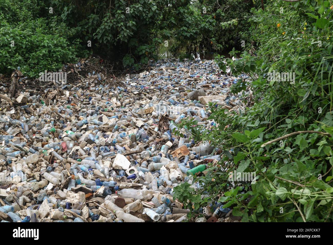 A view of a river heavily polluted with plastic drinks bottles in ...