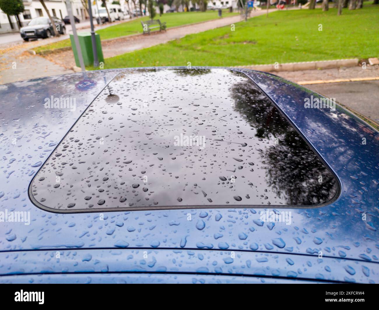 Car sunroof covered with thick rain drops. Outdoor picture Stock Photo