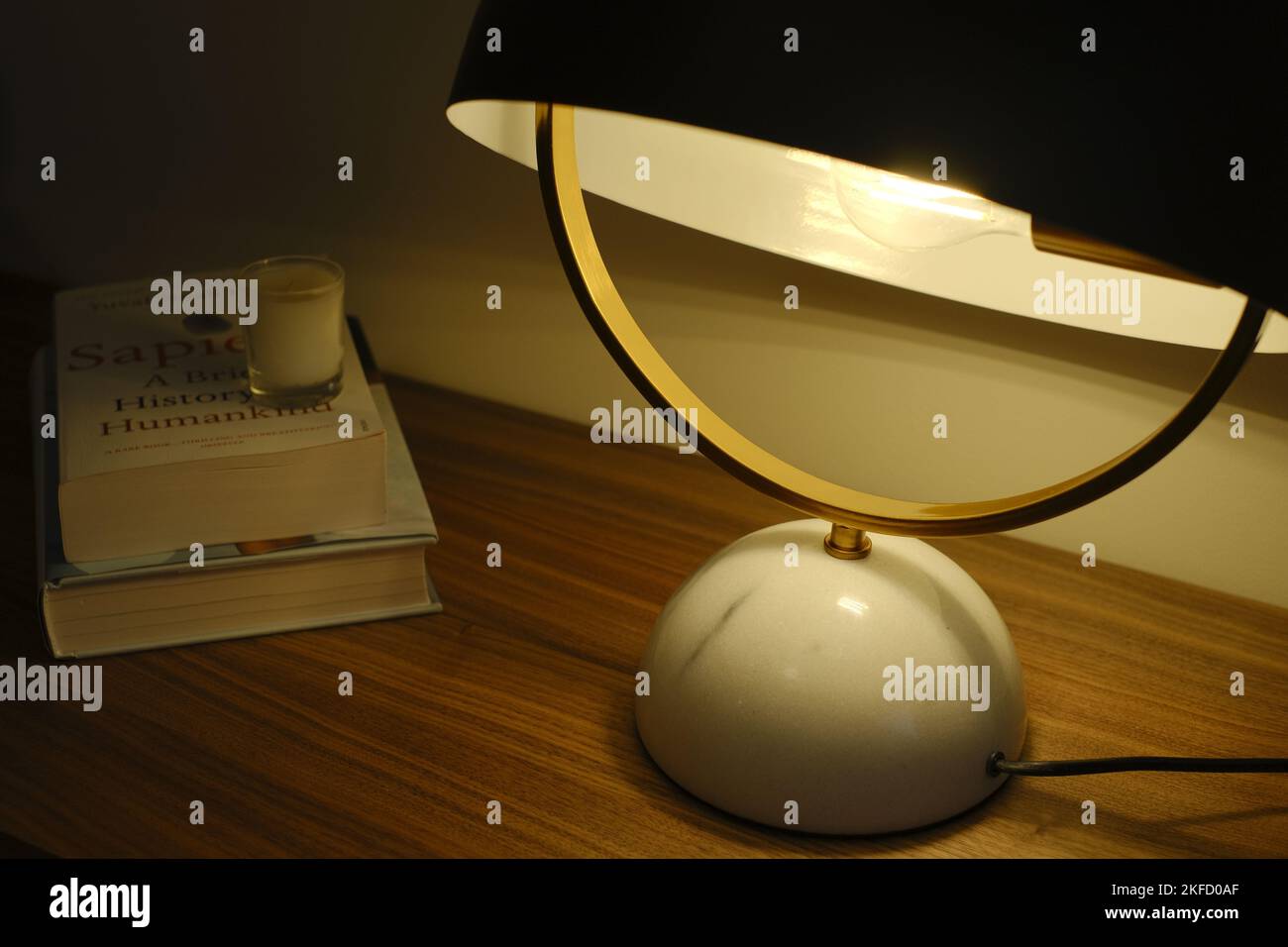 A moody table with retro lamp and a stack of books Stock Photo - Alamy