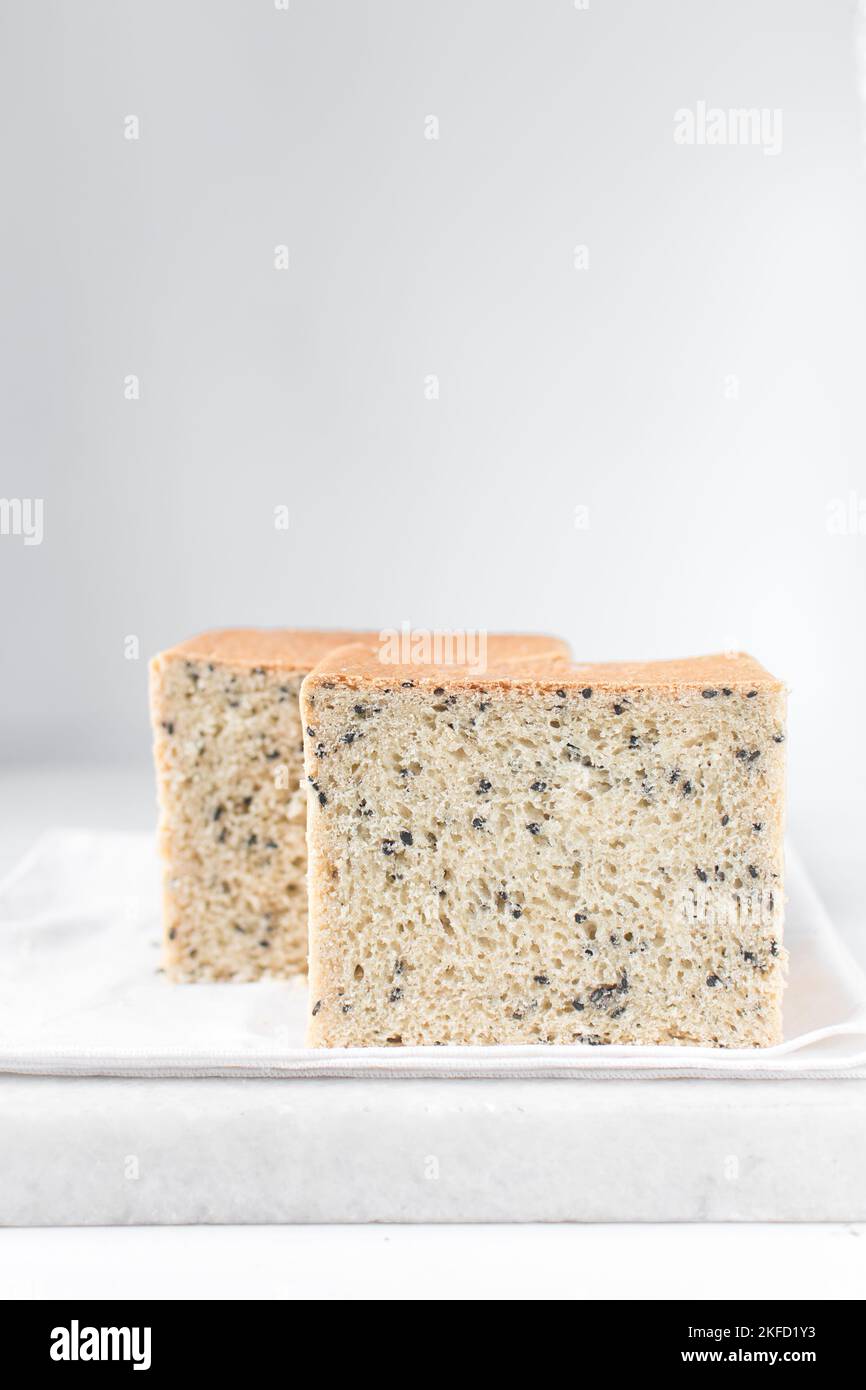 Black sesame seed bread on a white chopping board, poppy seed bread, pullmans loaf, sandwich