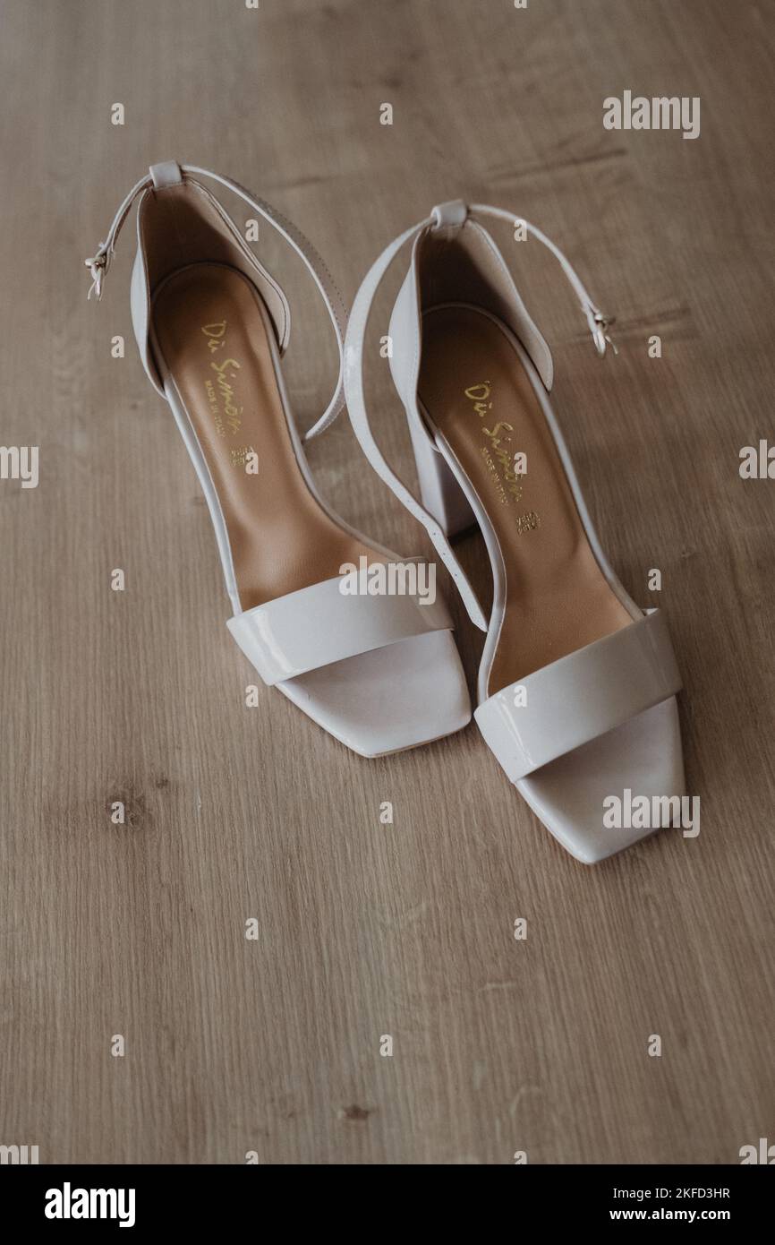 A vertical shot of a pair of creamy bridal shoes Stock Photo