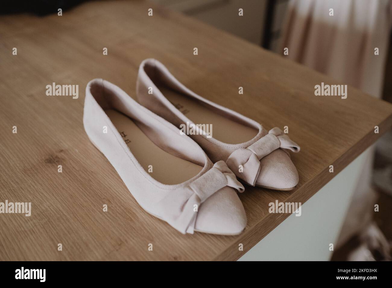 A pair of creamy bridal shoes on the tabel Stock Photo