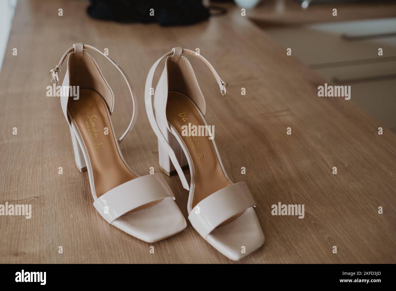 A pair of creamy bridal shoes on the tabel Stock Photo