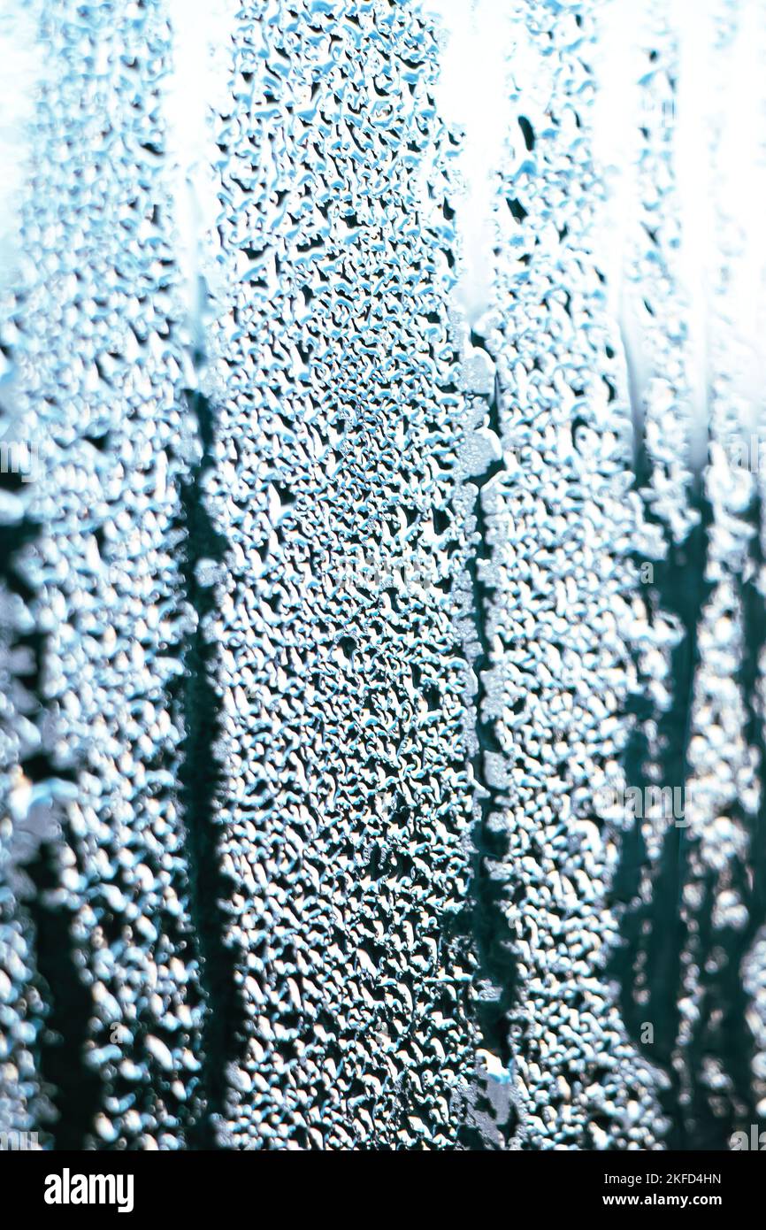 Texture of misted glass in autumn. Drops of water on window in rainy weather. Abstract background. Vertical photo. Stock Photo