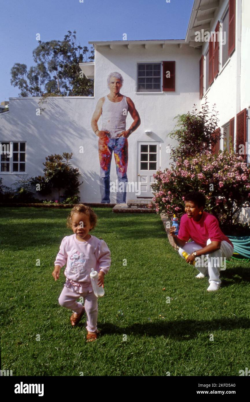 Peter Norton's wife Eileen and daughter in backyard of home with mural by Kent Twitchell of artist Don Bachardy in Santa Monica, CA, 1989 Stock Photo
