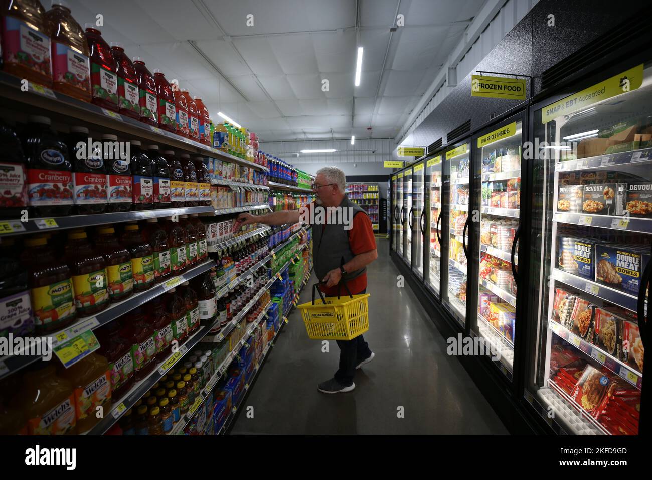 A senior man picking a product in the soft drinks aisle at Dollar