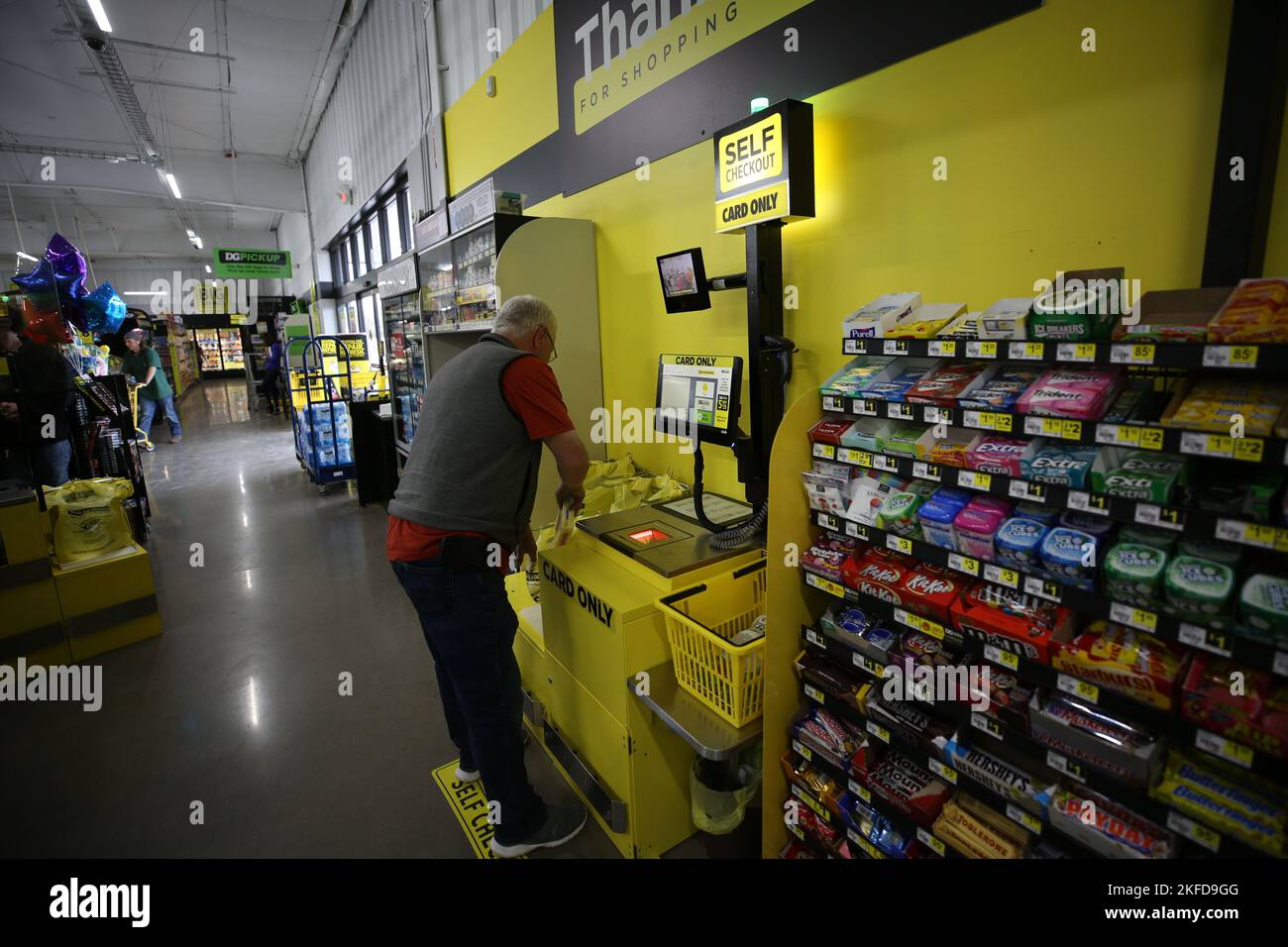 A senior man using the selfcheckout kiosk at Dollar General Stock