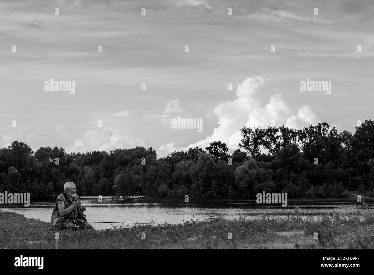 A black and white of a fisherman fishing on the lake in Belarus Stock
