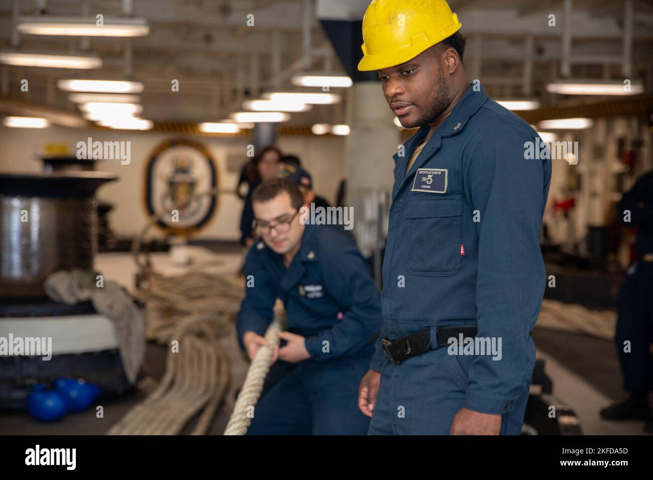 220908-N-VO895-1055  ATLANTIC OCEAN (Sept. 8, 2022) Boatswain’s Mate 3rd Class Benjamin Hughes, assigned to the Wasp-class amphibious assault ship USS Bataan (LHD 5) Deck Department, ensures lines are heaved in, in the ship’s forecastle, Sept. 8, 2022. Bataan is underway conducting an Afloat Training Group engineering inspection as part of the basic phase training cycle. Stock Photo