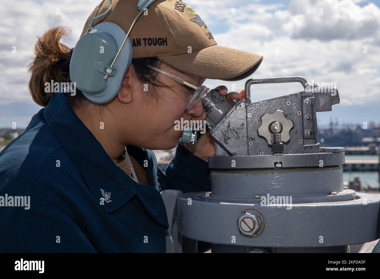 220908-N-VO895-1022  ATLANTIC OCEAN (Sept. 8, 2022) Quartermaster 3rd Class Leyda Perez, assigned to the Wasp-class amphibious assault ship USS Bataan (LHD 5) Navigation Department, uses an alidade to mark bearings on the ship’s observation deck, Sept. 8, 2022. Bataan is underway conducting an Afloat Training Group engineering inspection as part of the basic phase training cycle. Stock Photo