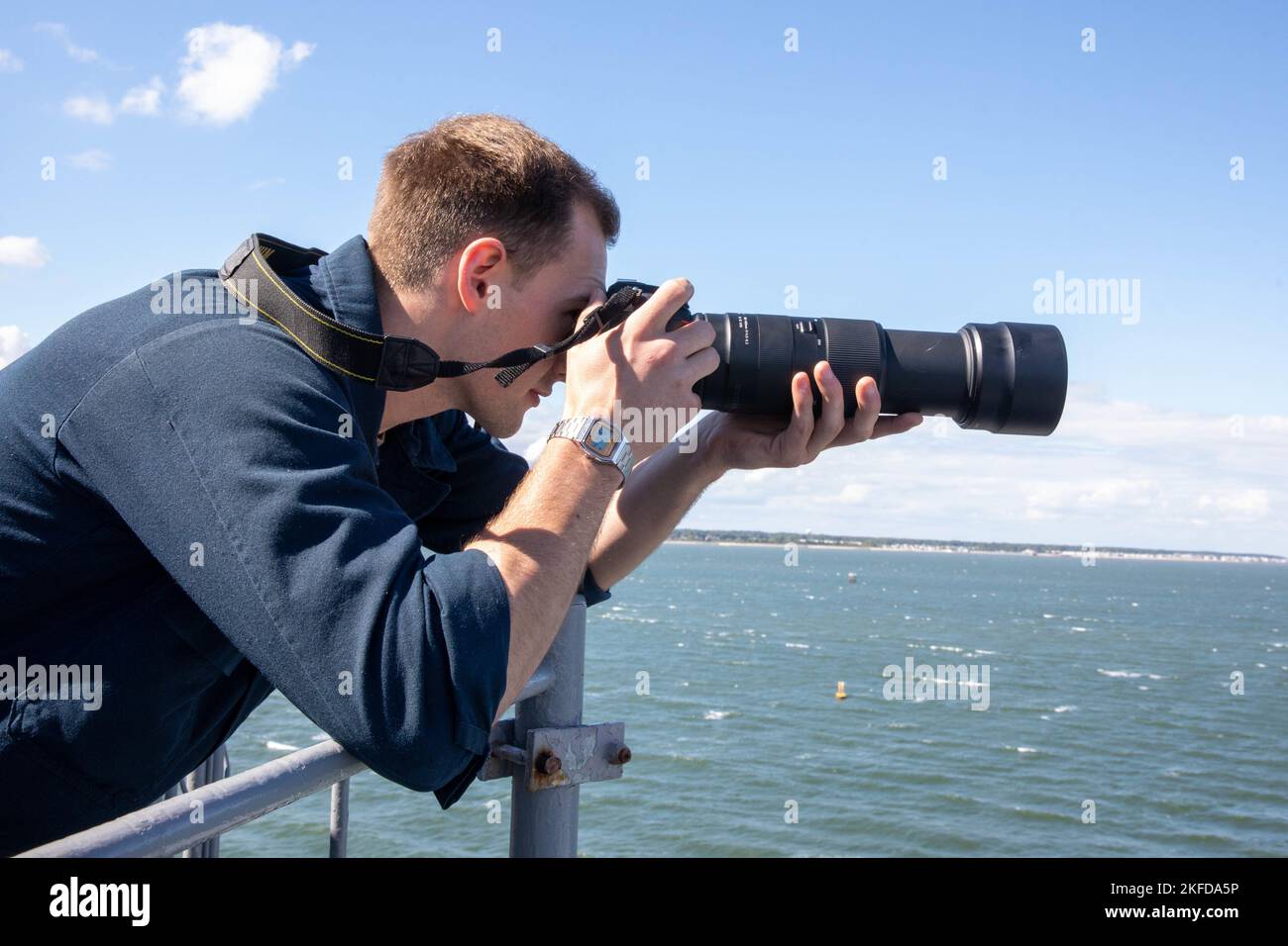 220908-N-VO895-1115  ATLANTIC OCEAN (Sept. 8, 2022) Intelligence Specialist Seaman Jaxon Cuddeback, assigned to the Wasp-class amphibious assault ship USS Bataan (LHD 5) C5I Department, takes photos of a sea contact on the ship’s observation deck, Sept. 8, 2022. Bataan is underway conducting an Afloat Training Group engineering inspection as part of the basic phase training cycle. Stock Photo