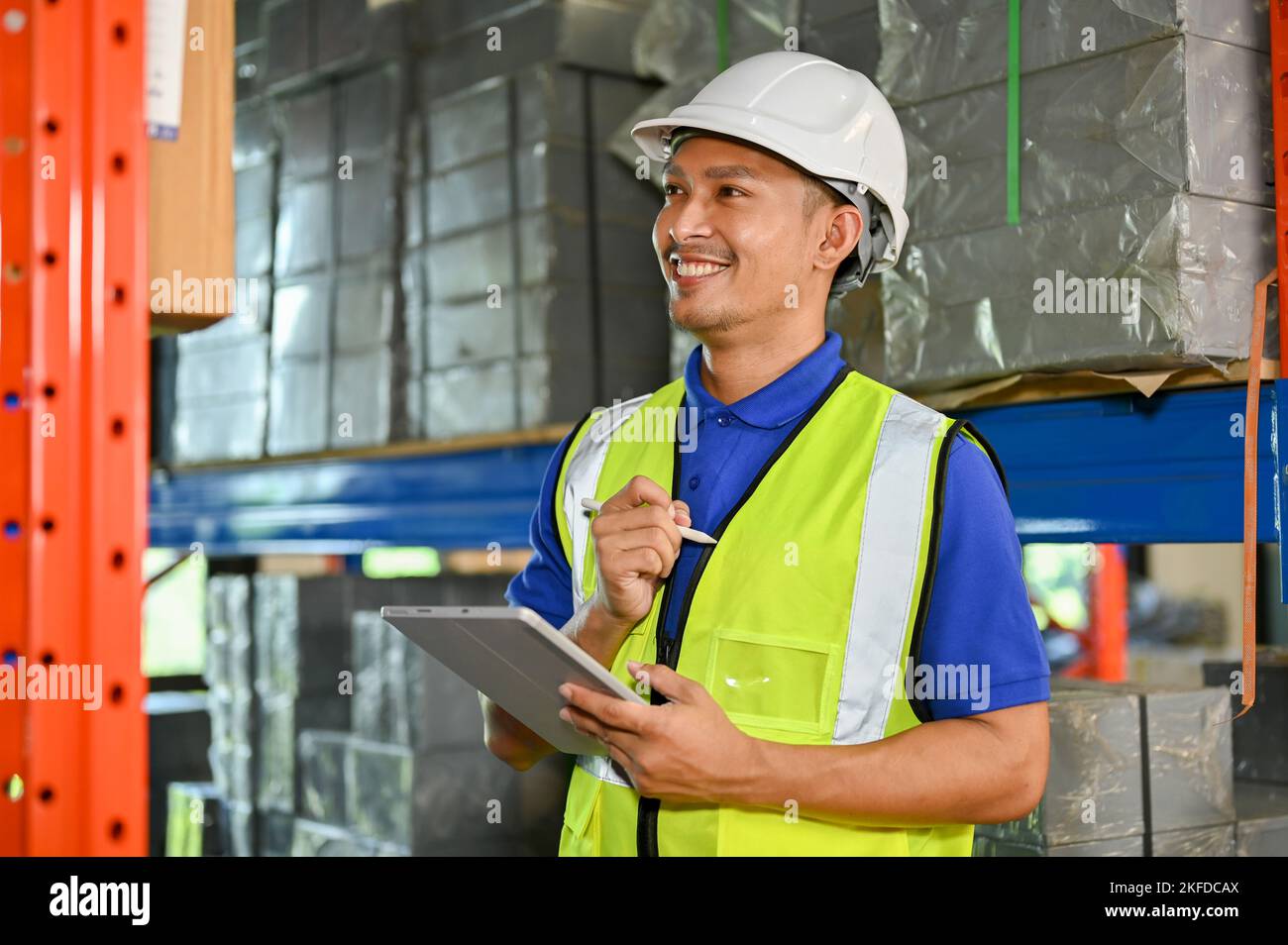 Happy and smart millennial Asian foreman or warehouse worker in a white