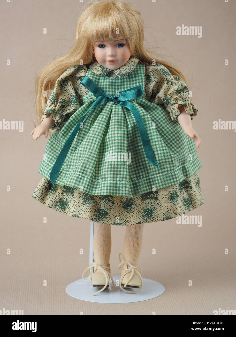 Vintage porcelain doll girl with blue eyes with flowing golden hair in
