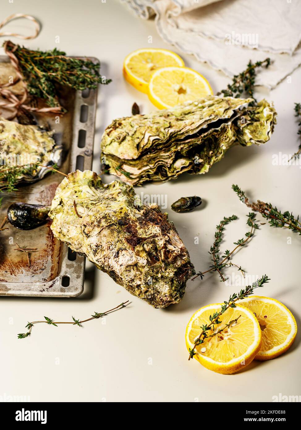 Giant fresh Pacific oysters on a light background. Lemon and oregano ...