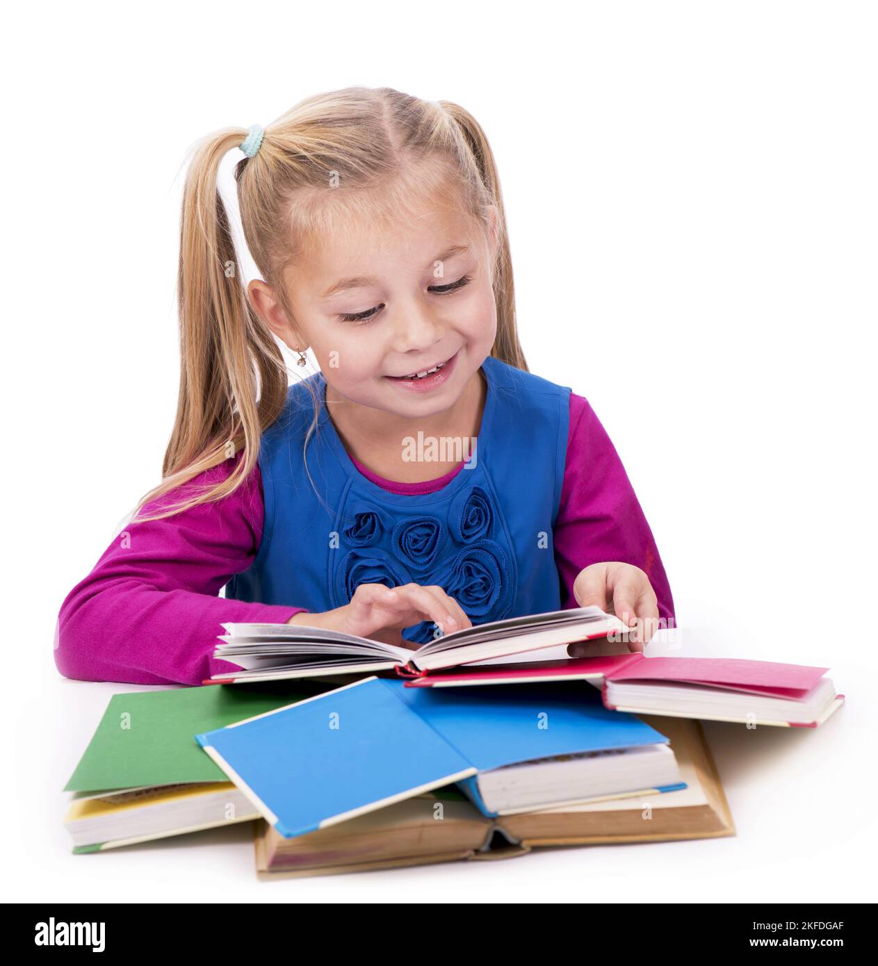 Little smart girl holding a book and reading it, on a white background