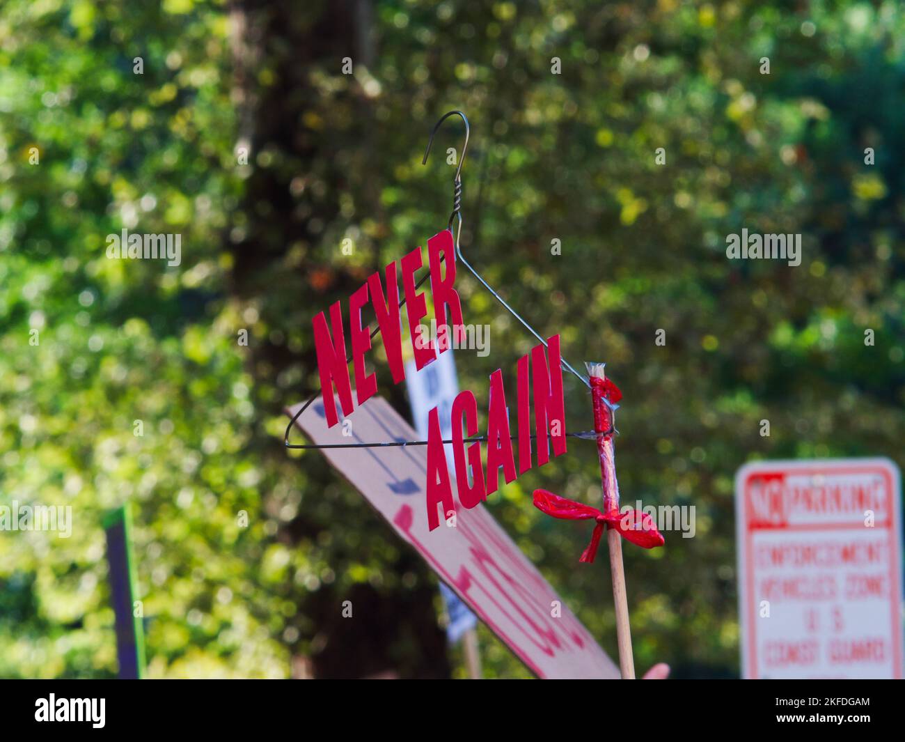 A protest sign of a wire hanger with the words Never Again at a pro-choice protest in New Orleans, USA Stock Photo