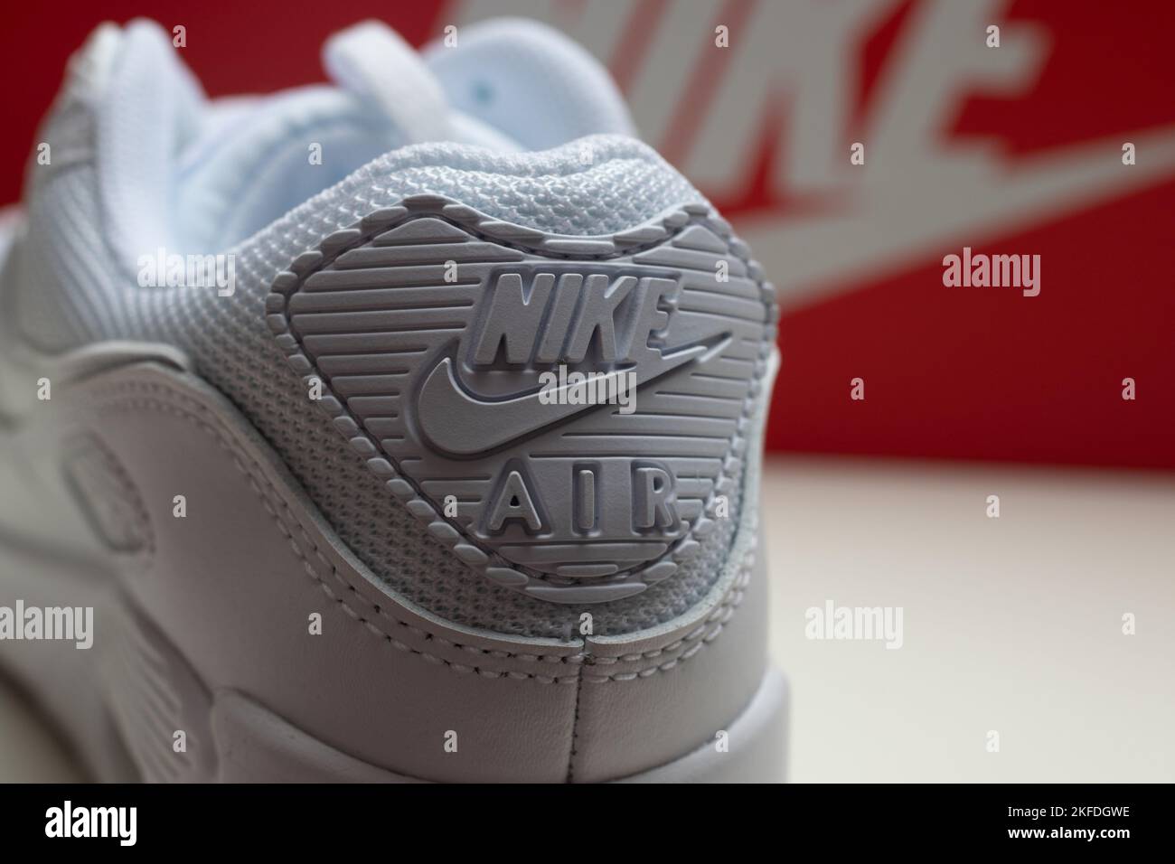 A closeup of triple white Nike Air Max 90 sneaker. The heel tab with the brand name and logo. Stock Photo