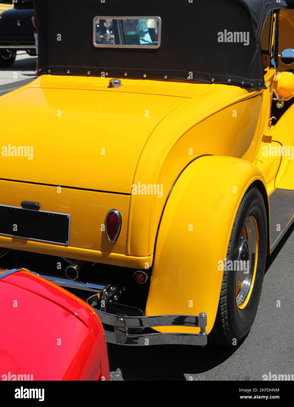 A detail of a rear end of a yellow hotrod car Stock Photo