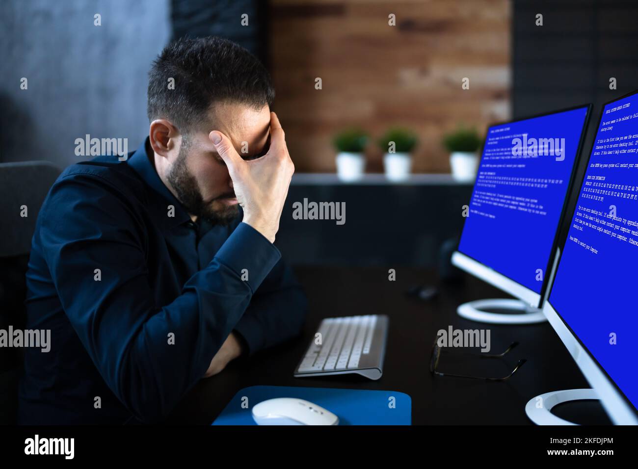 Worried Man At Computer With System Failure Screen At The Workplace Stock Photo