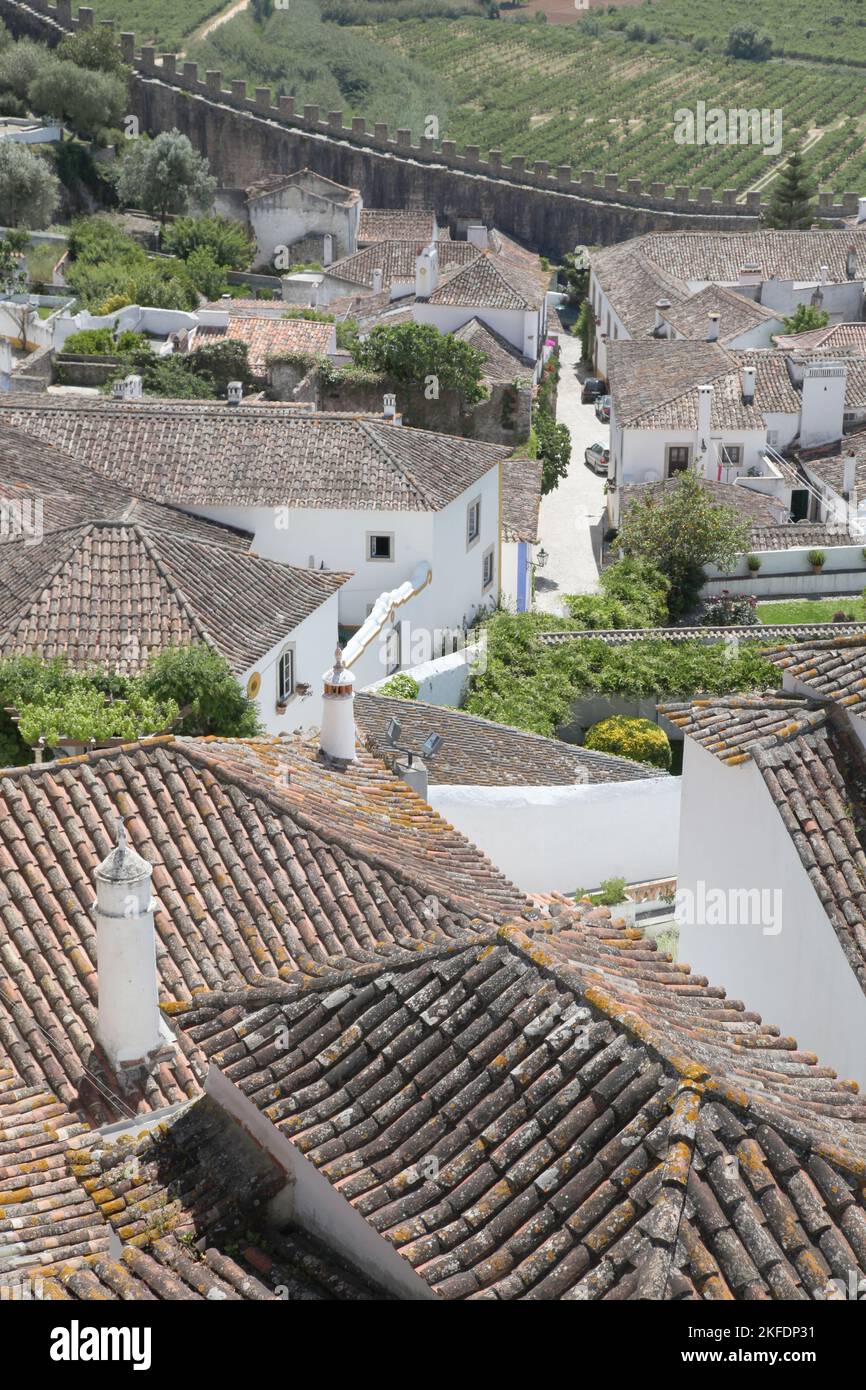 A view across the roof tops on the Portuguese ton of Obidos. The historic town is a very popular tourist destination in Western Portugal. Stock Photo