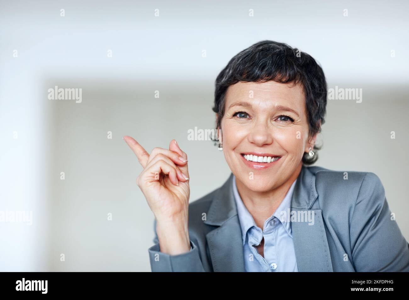Female executive pointing at something. Portrait of mature business ...