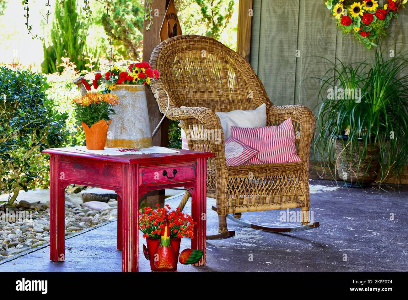 Rocking Inside Table A wicker rocking chair, red table with pot plants inside a wooden house ...