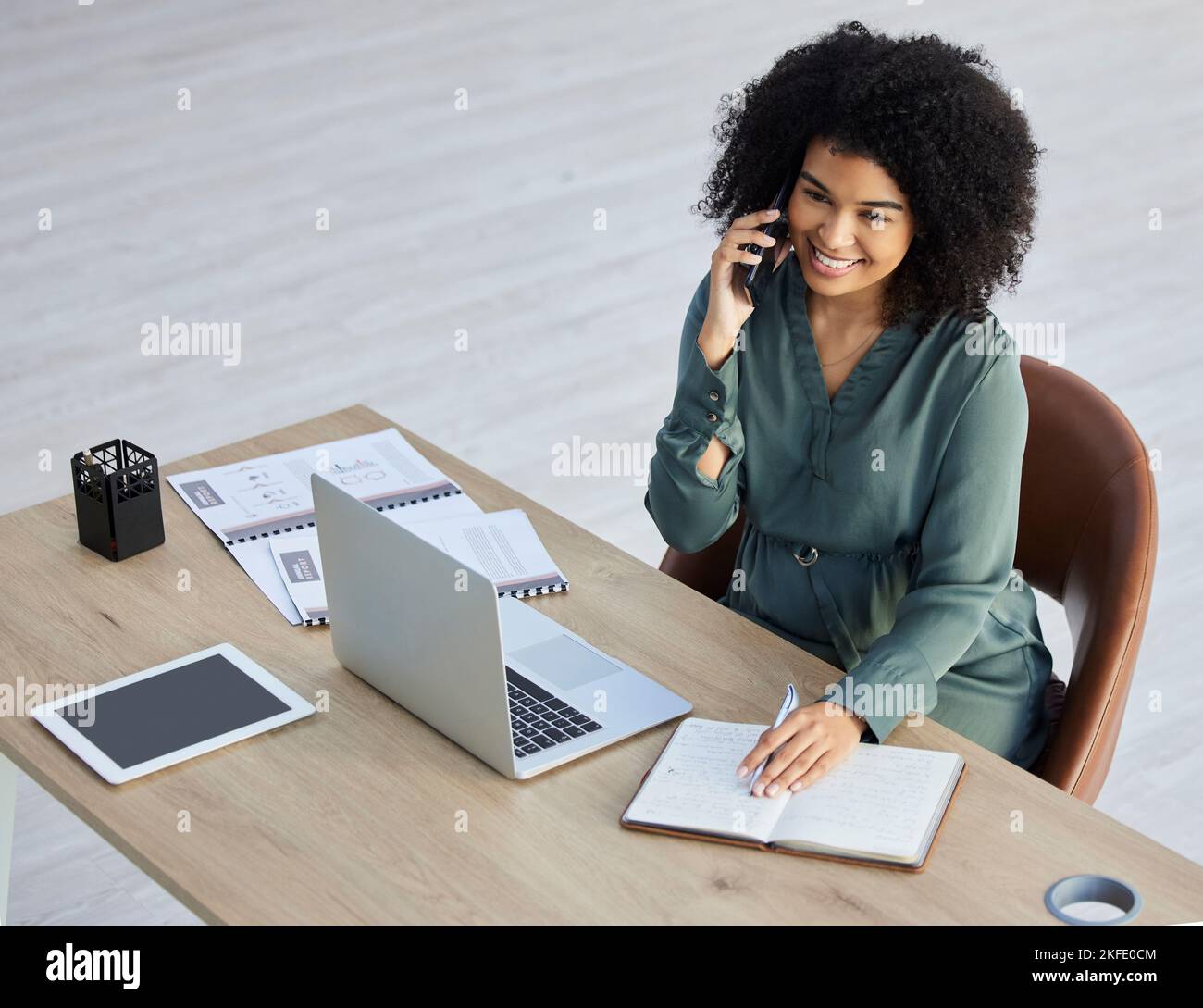 Business woman, laptop and phone call in office for tech communication or digital marketing planning. African girl. corporate workplace and networking Stock Photo