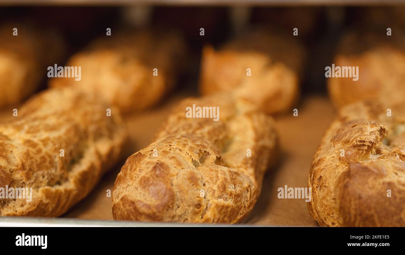 Eclair shells come out of the oven in an industrial bakery Stock Photo ...