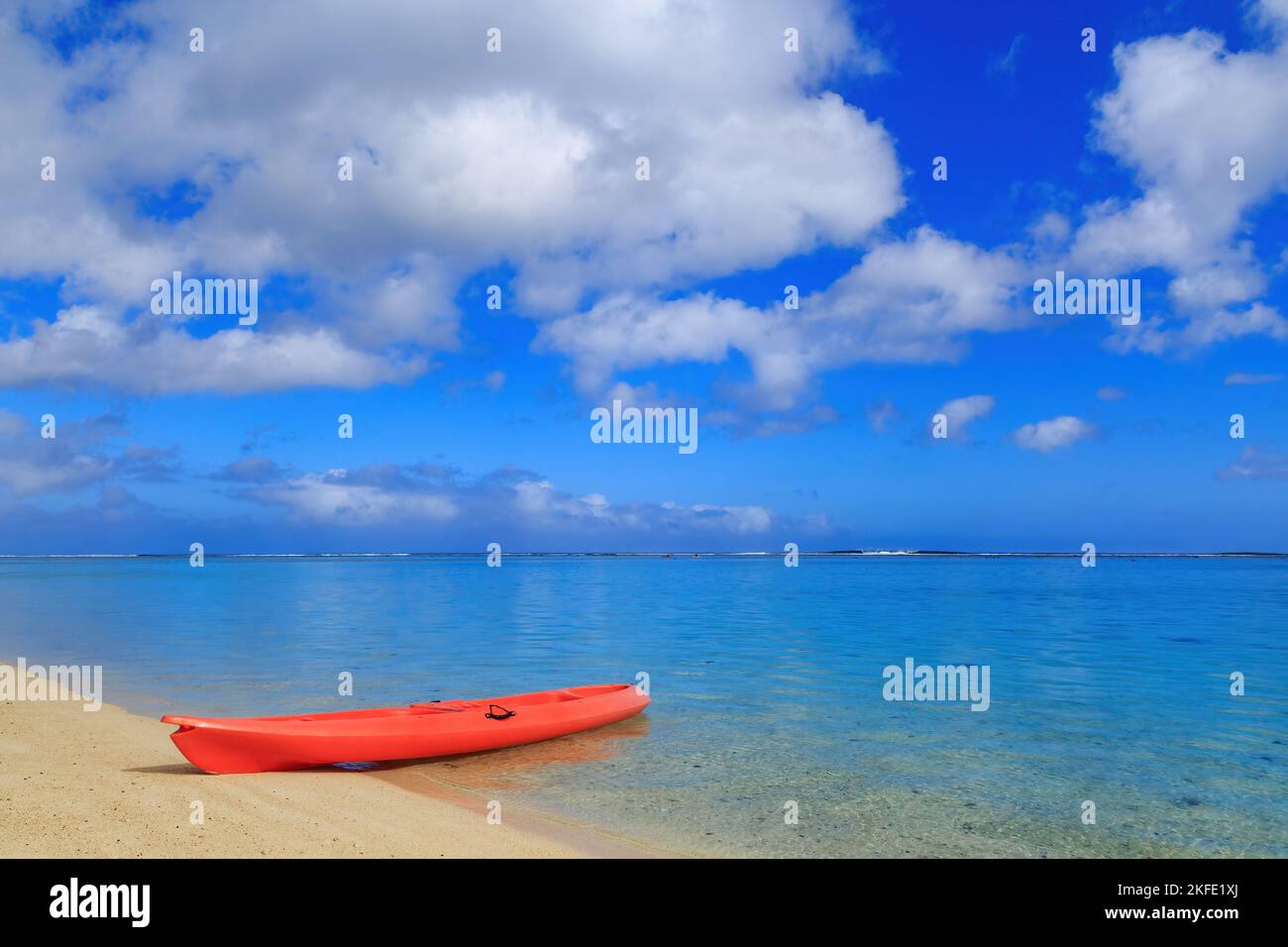 Kayak on the edge of a vast tropical lagoon, with a blue sky above. Aroa Beach, Rarotonga, Cook