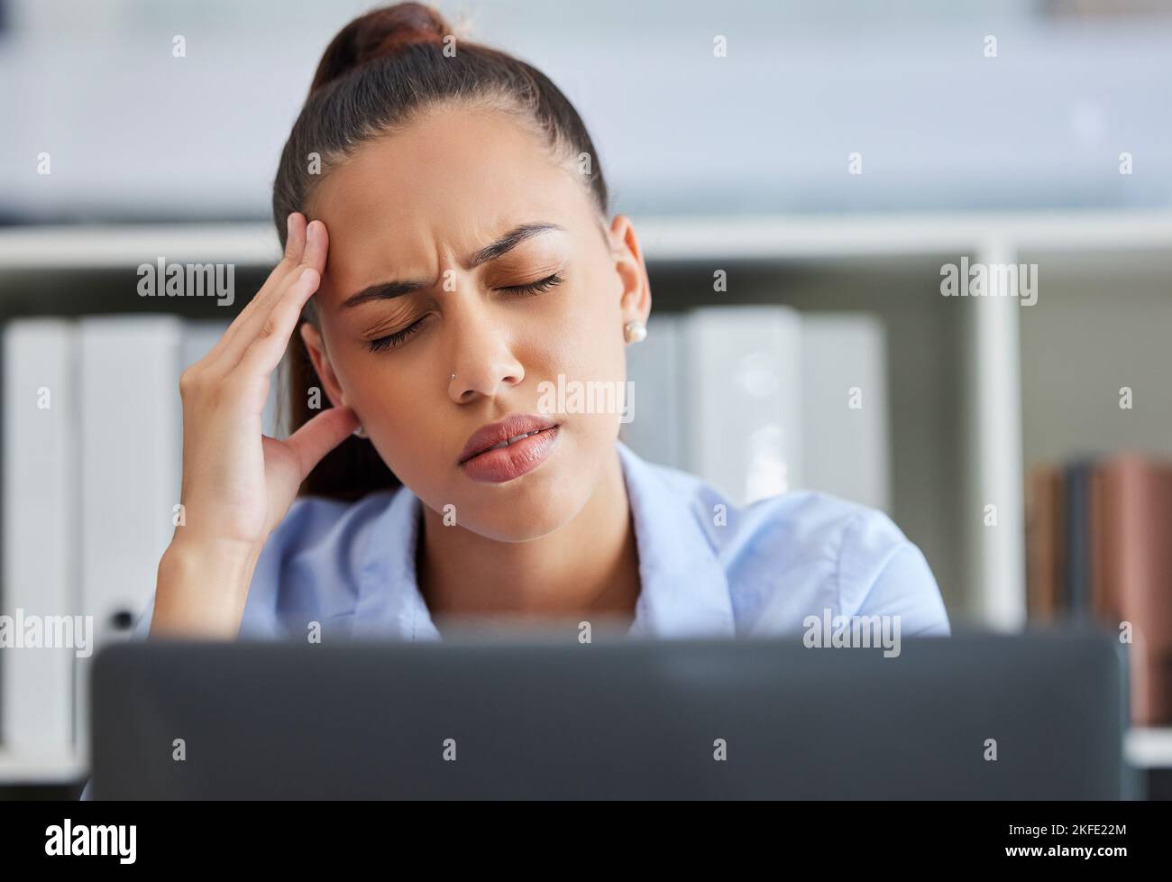 Headache, stress and burnout of business woman at computer with pain, stress and depression while tired and frustrated with work. Female entrepreneur Stock Photo