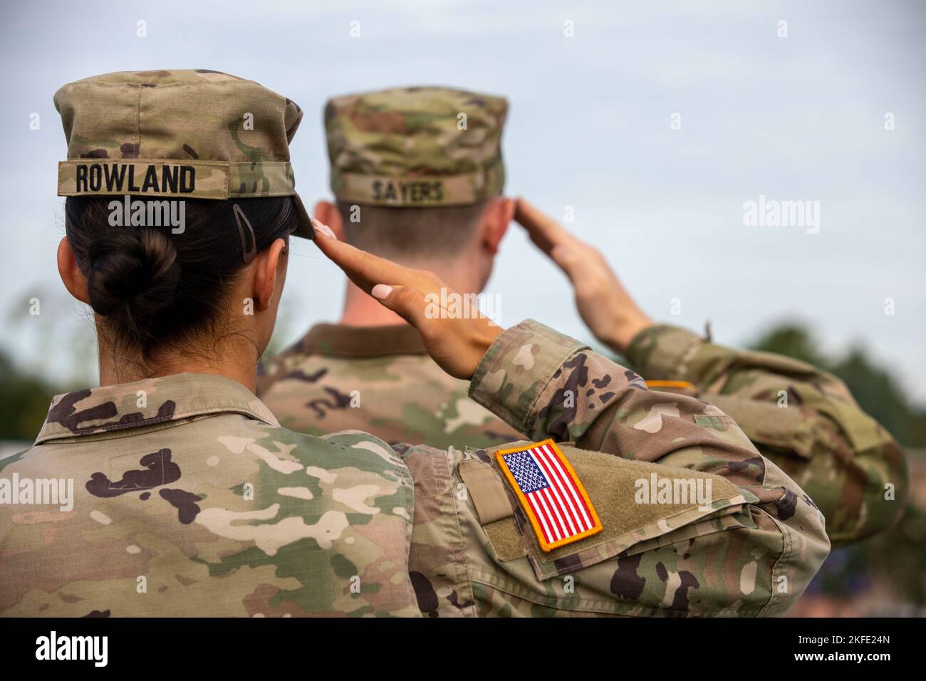 U.S. Army Soldiers with the Vermont National Guard salute the American flag during the National Anthem, in Colchester, Vermont, Sep 11, 2022. The Soldiers were there to honor the memory of those who lost their lives during and since the events of 9/11. Stock Photo