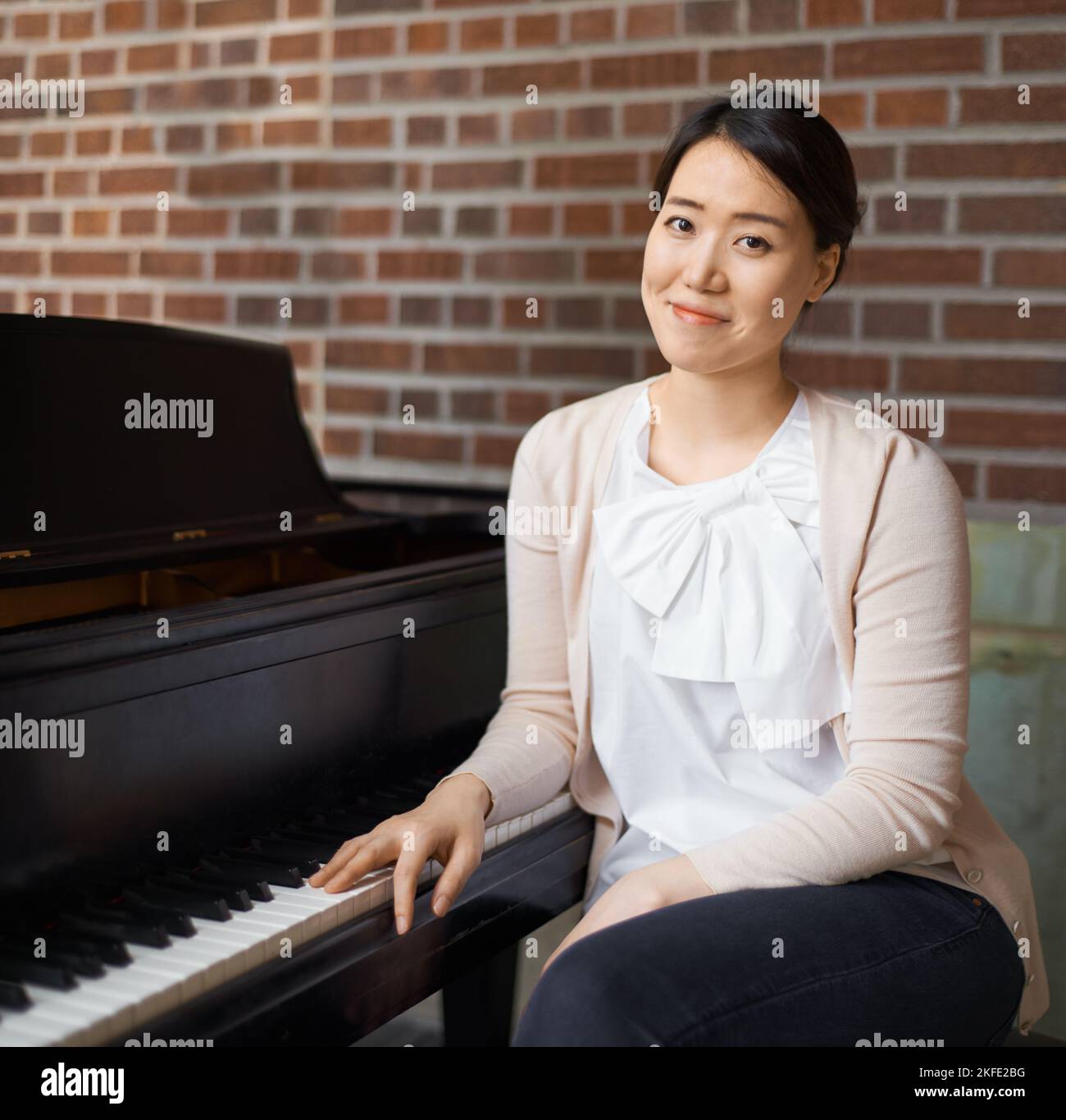Portrait Asian woman playing playing piano Stock Photo - Alamy