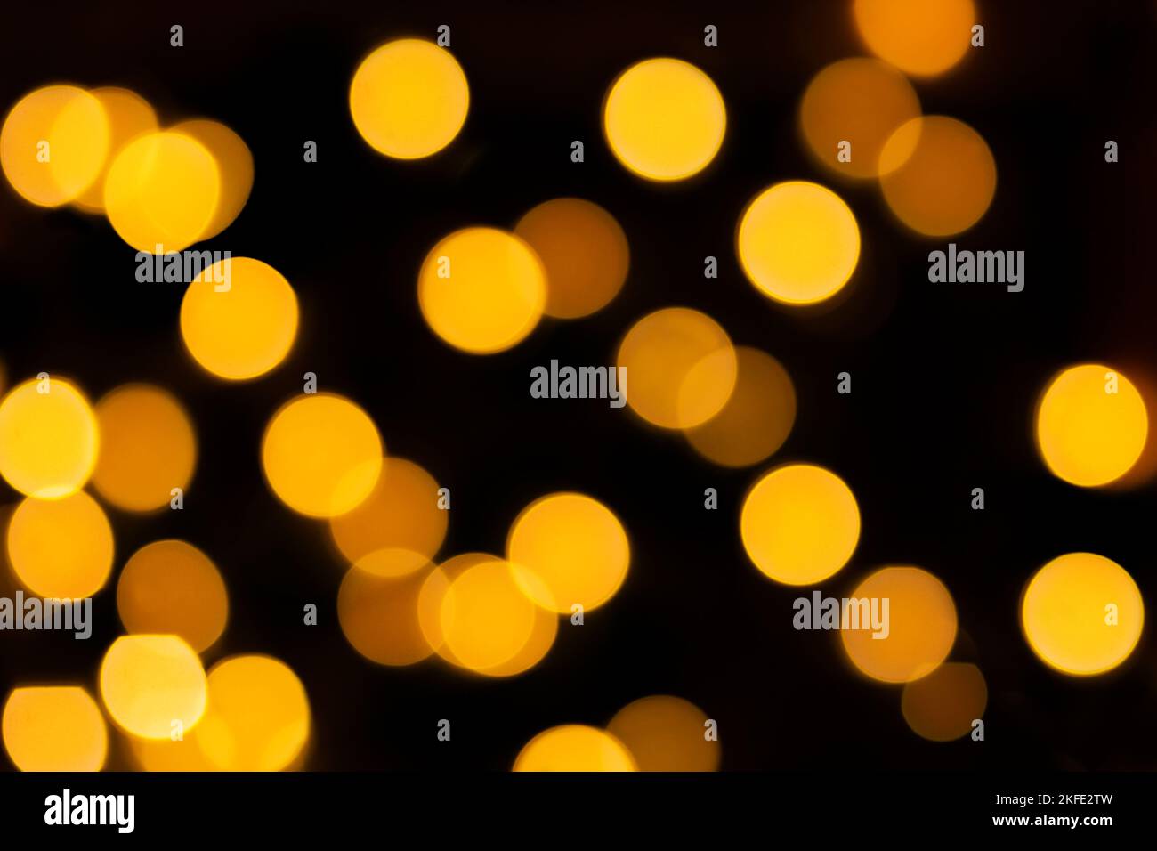 Yellow blurred bokeh on black isolated background. Defocused lights. For overlay design. New Year, Christmas, holiday Stock Photo